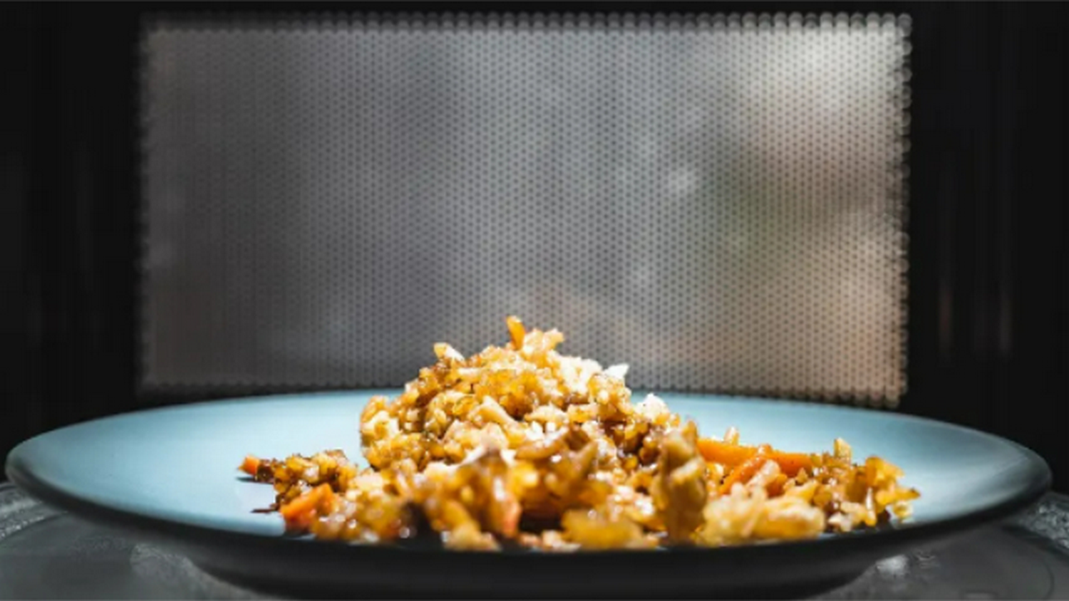 Un plato de arroz frito dentro de un microondas.
