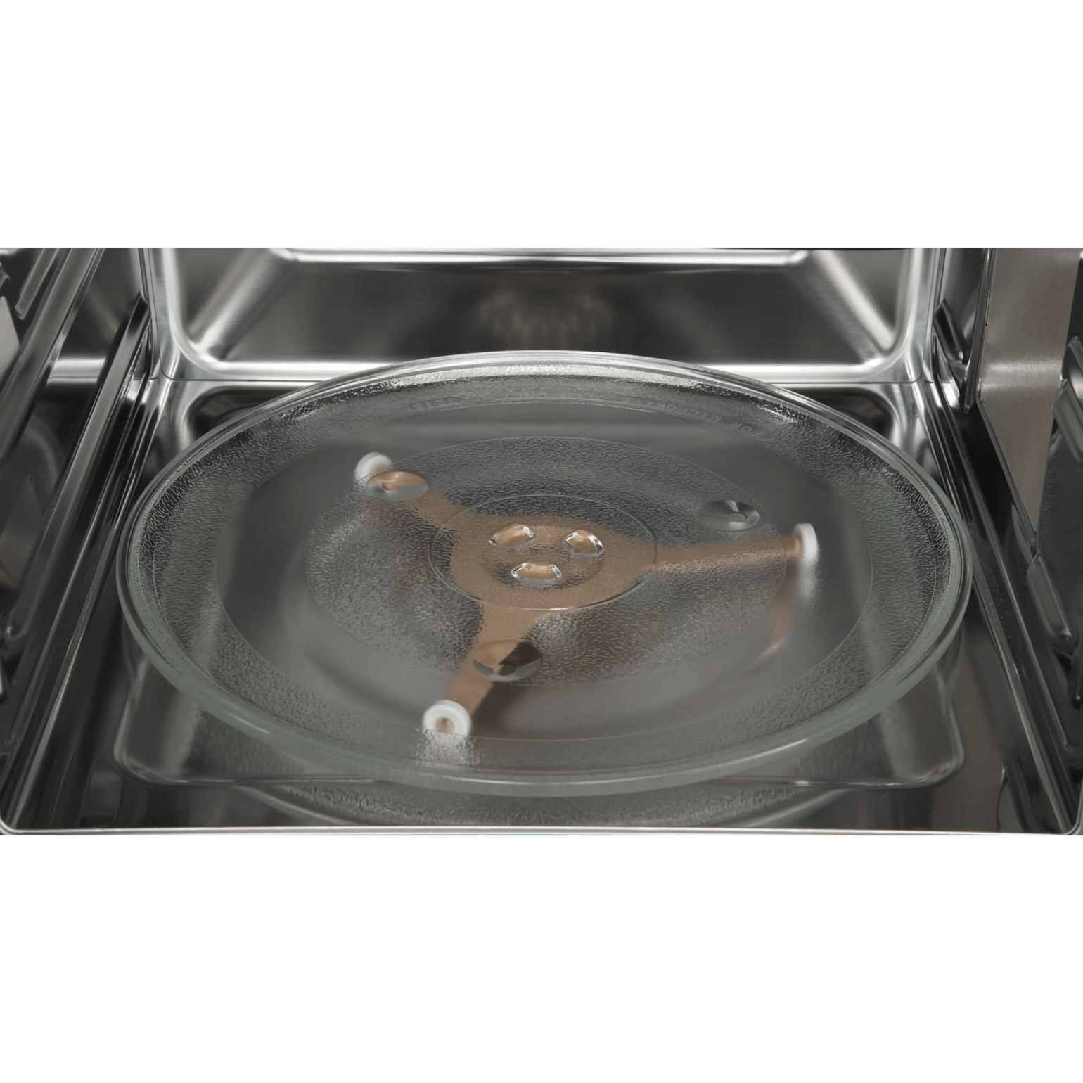 El interior de un microondas limpio con un plato giratorio de vidrio y un anillo.