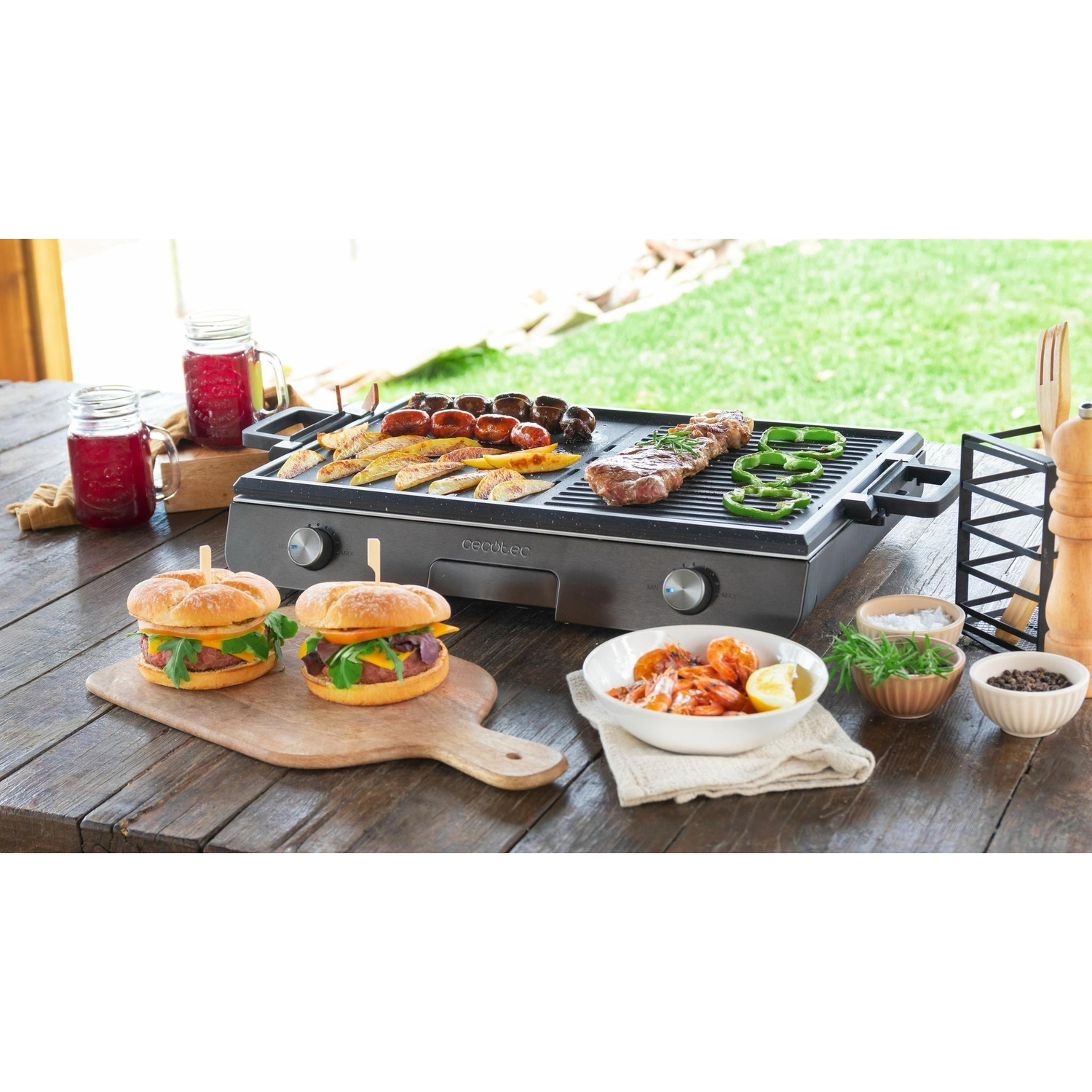 Un grill elettrico da tavolo all'aperto, con hamburger, carne, verdure e bevande.