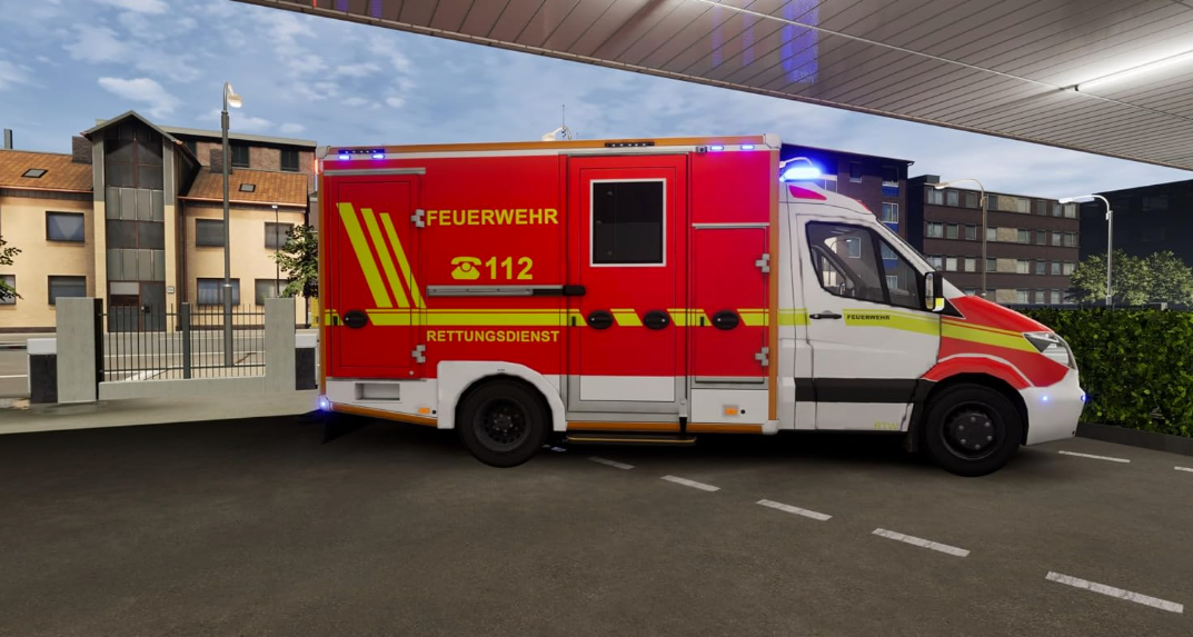 Ein rot-weißes deutsches Rettungsfahrzeug parkt unter einem Unterstand vor Gebäuden.
