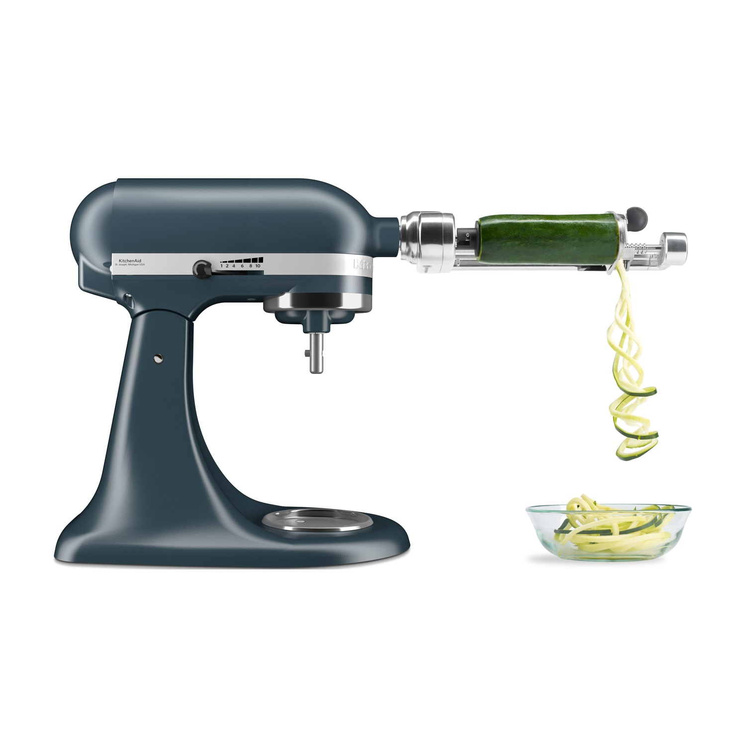 Impastatrice blu con accessorio tagliaverdure a spirale che affetta zucchine sopra una ciotola.