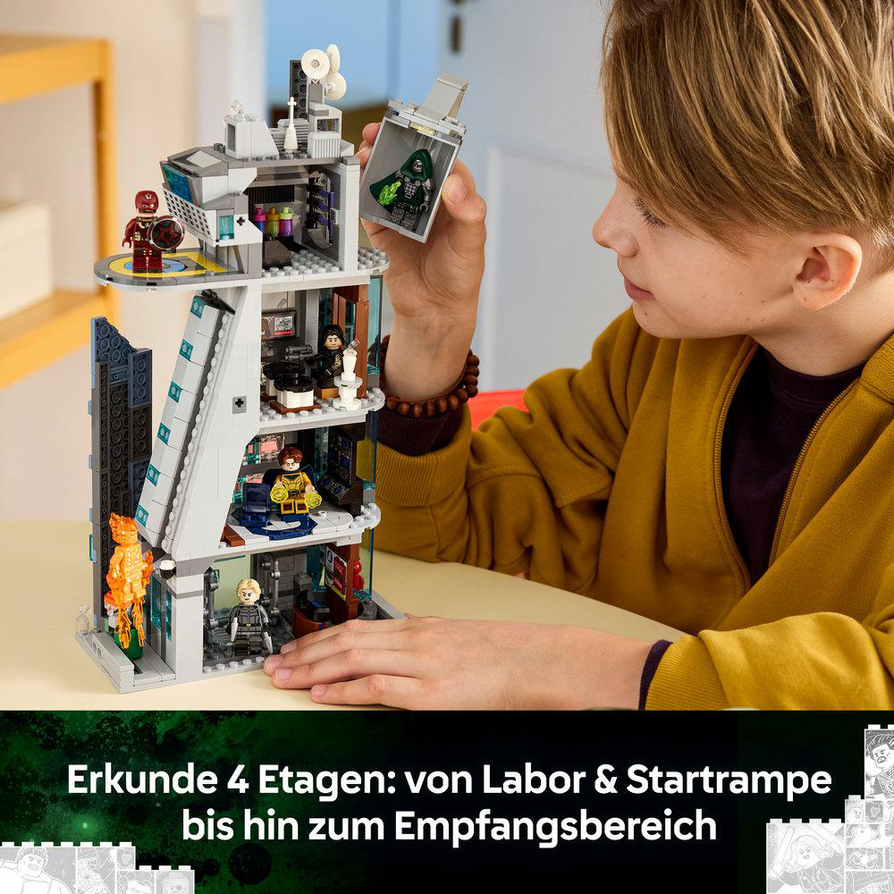 Ein Junge baut einen vierstöckigen Lego-Turm mit Figuren und Räumen.