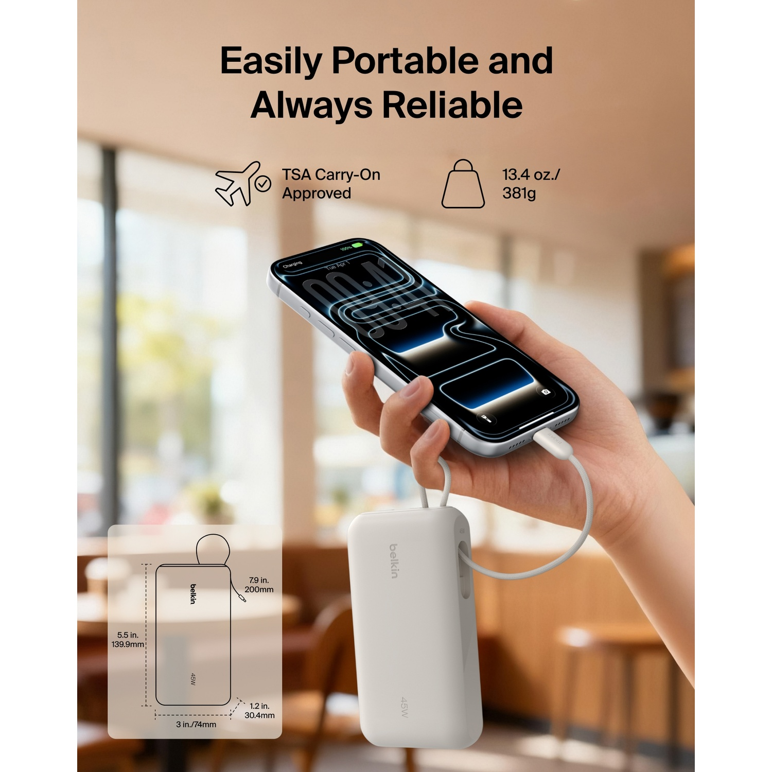 Une main tient un smartphone en cours de chargement par une batterie externe Belkin blanche portable à l'intérieur.