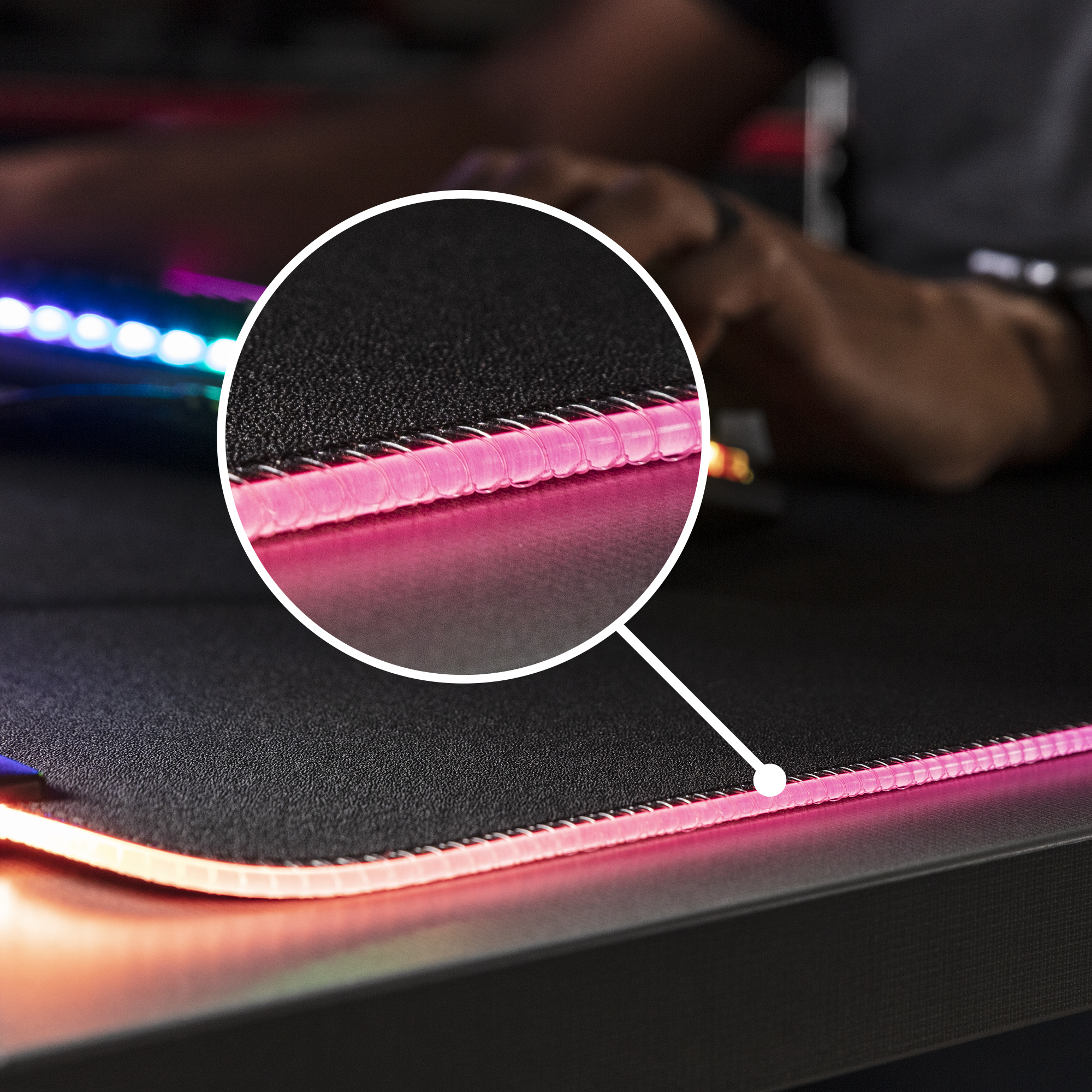 Kenarları dikilmiş, entegre LED aydınlatmalı oyuncu mousepad'inin yakın çekimi.