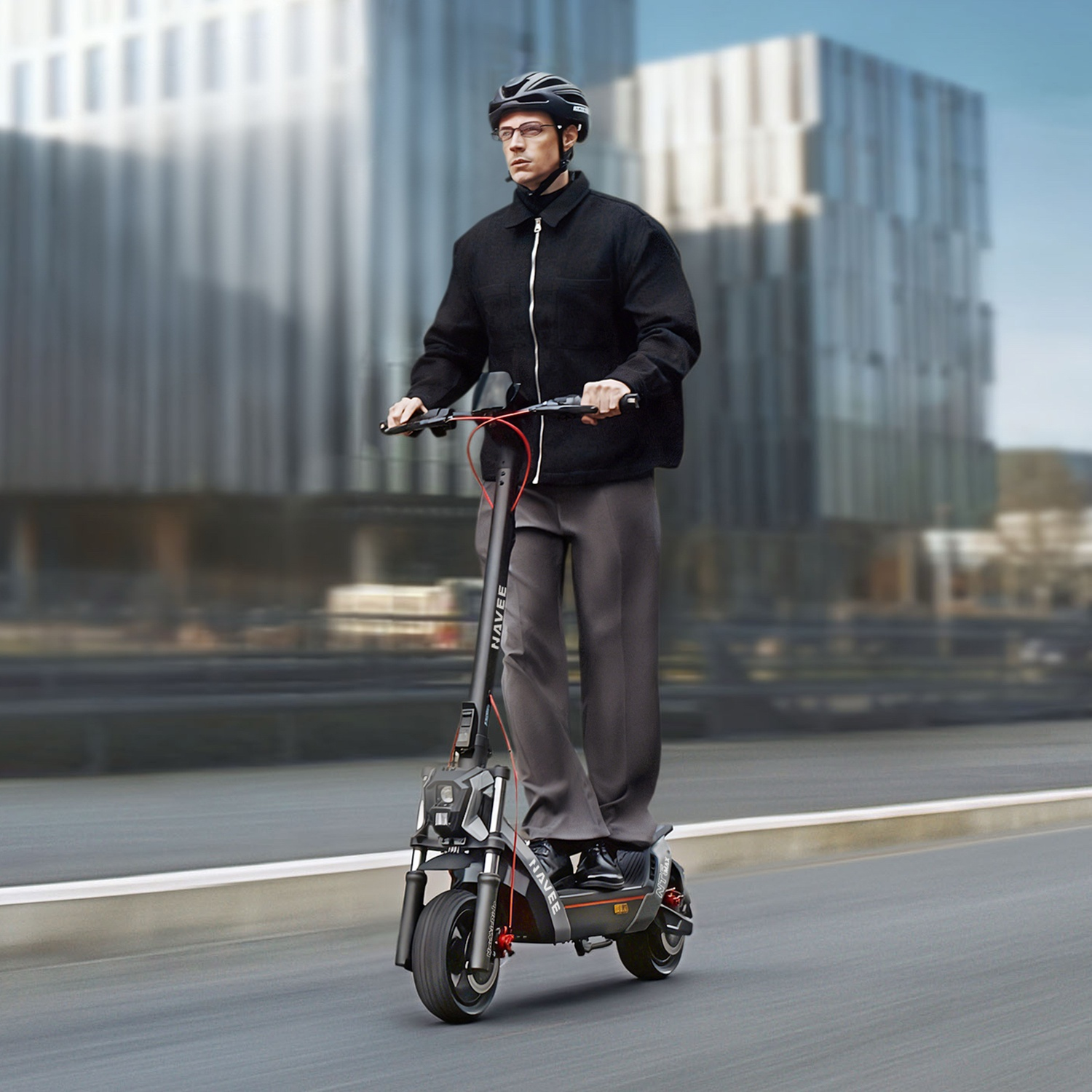 Un uomo con casco e occhiali guida un monopattino elettrico nero davanti a edifici moderni.