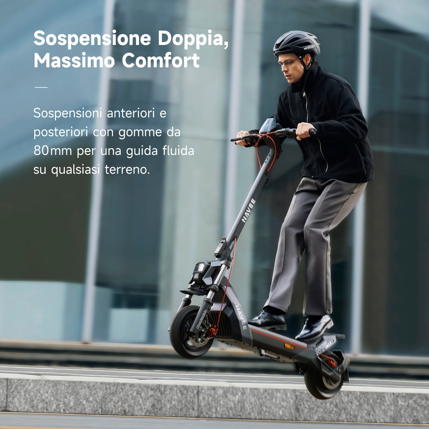 Un uomo con casco e giacca scura guida un monopattino elettrico scendendo da un marciapiede, testo in italiano a sinistra.