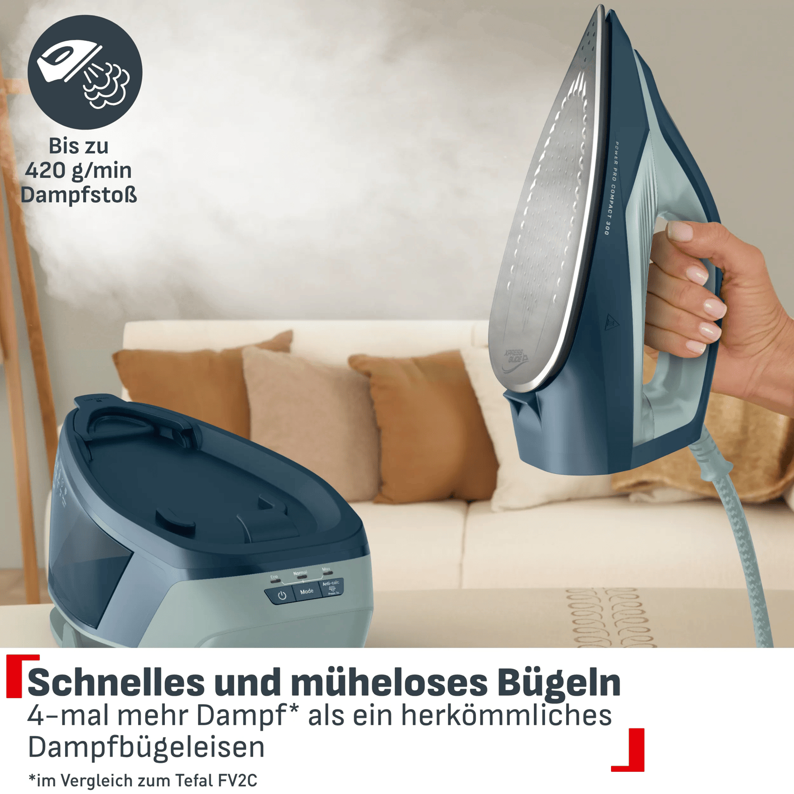 Eine Hand hält ein blaues Dampfbügeleisen über einer Basisstation vor einem Sofa mit Kissen.