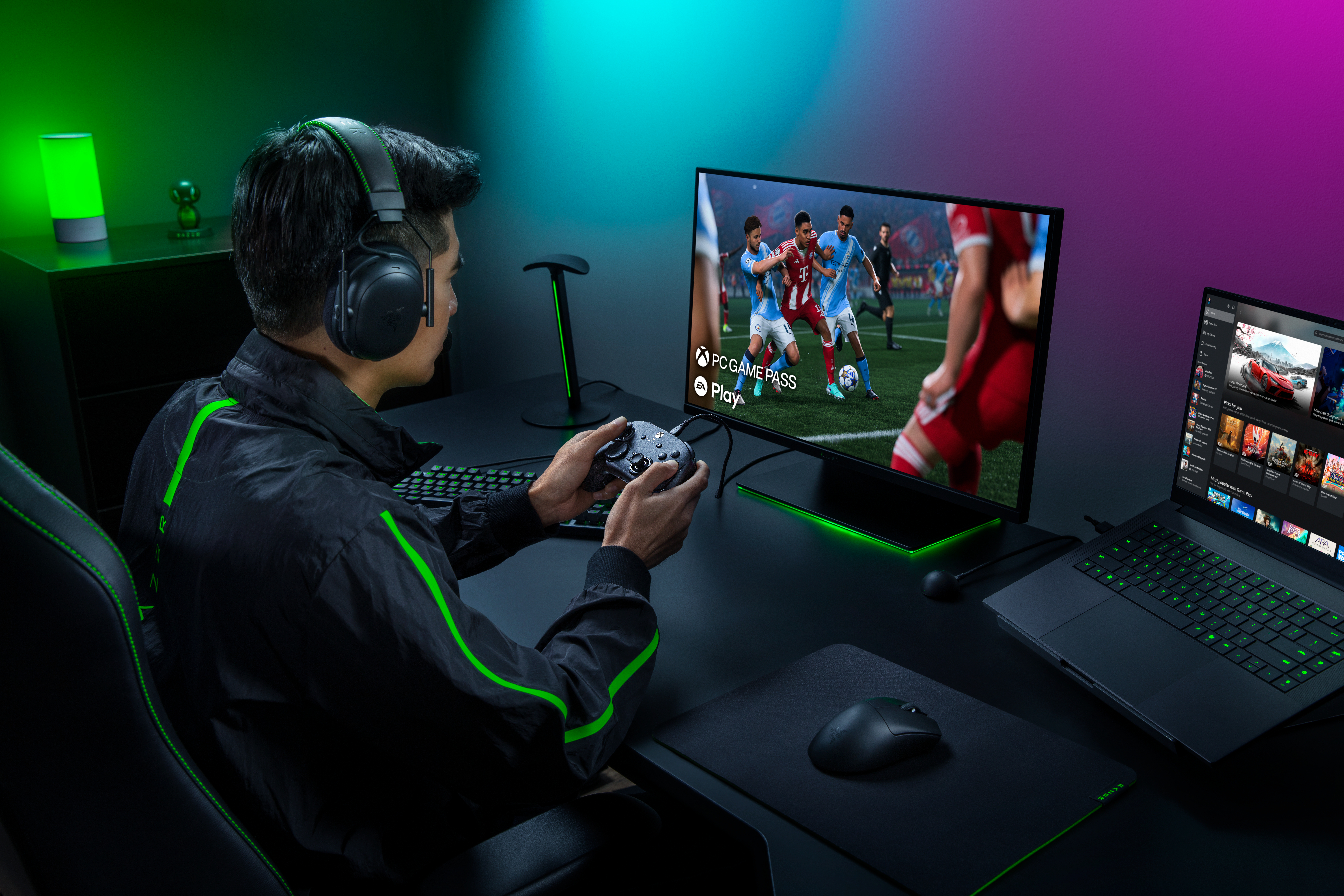 Ein Spieler mit Headset und Controller sitzt vor einem großen Monitor, auf dem ein Fußballspiel läuft.