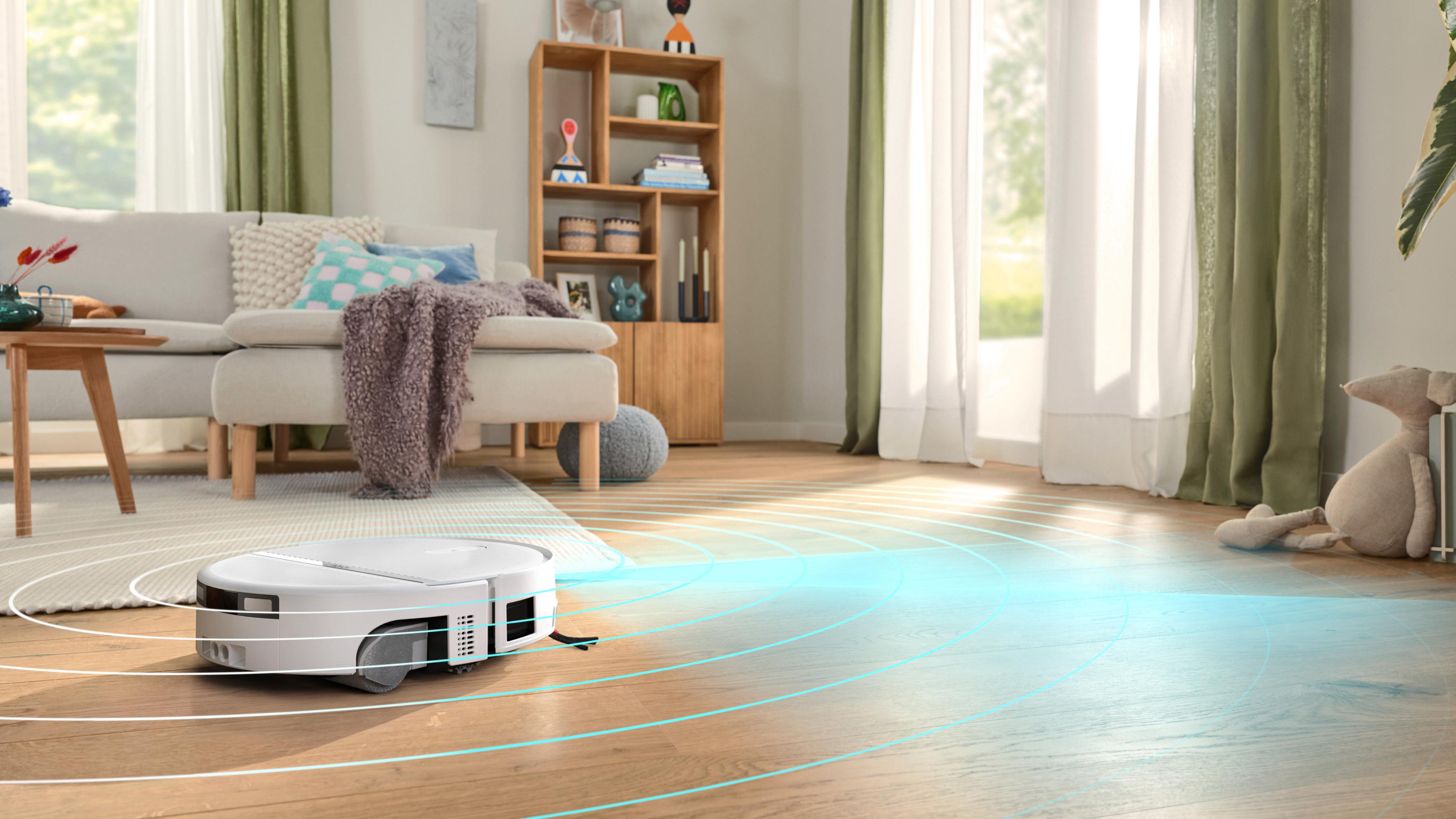 Ein weißer Saugroboter reinigt den Holzfußboden in einem hellen Wohnzimmer mit blauen Sensorempfängen.