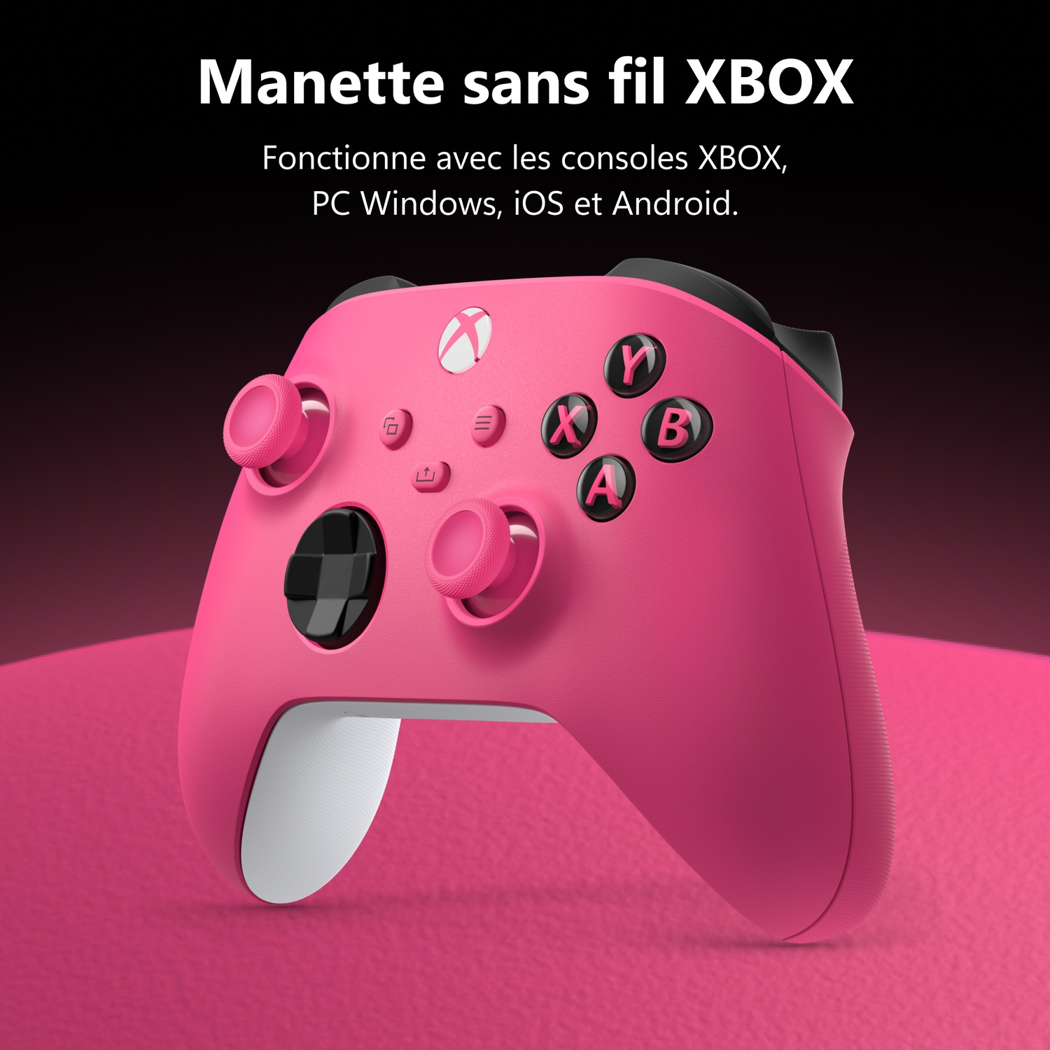 Une manette sans fil Xbox rose vif repose sur une surface rose devant un fond sombre.