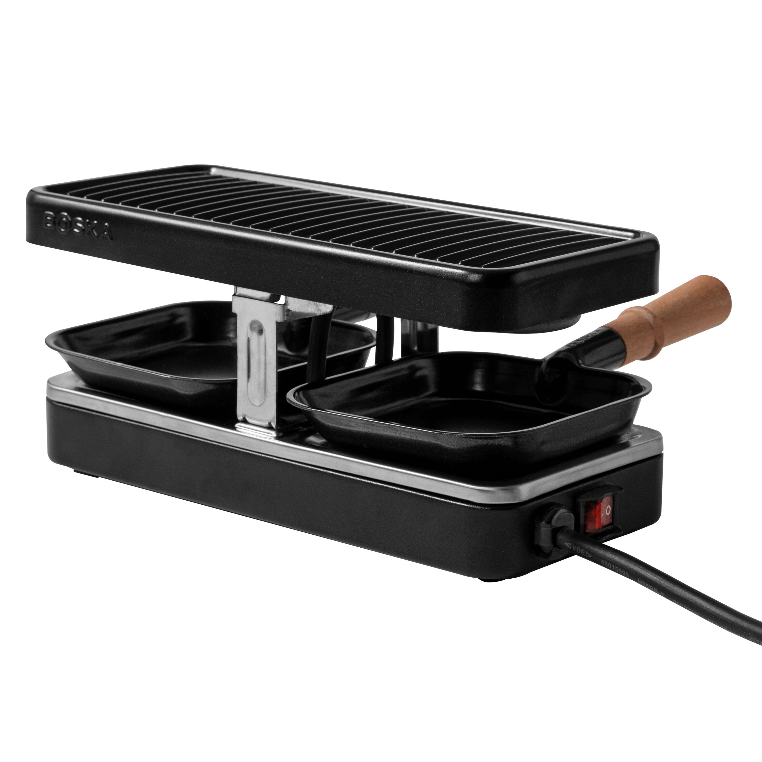 Schwarzer Raclette-Grill mit Grillplatte und zwei kleinen Pfännchen mit Holzgriffen auf weißem Grund.