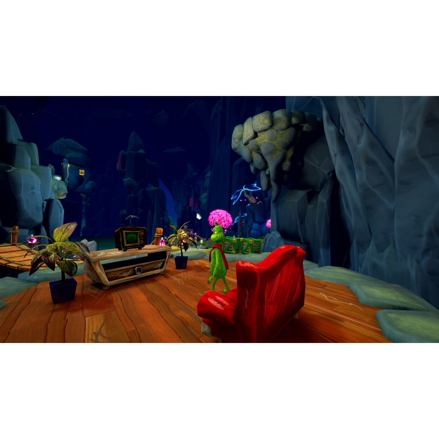 Green character stands before red armchair and TV in dark cave with wooden floor.