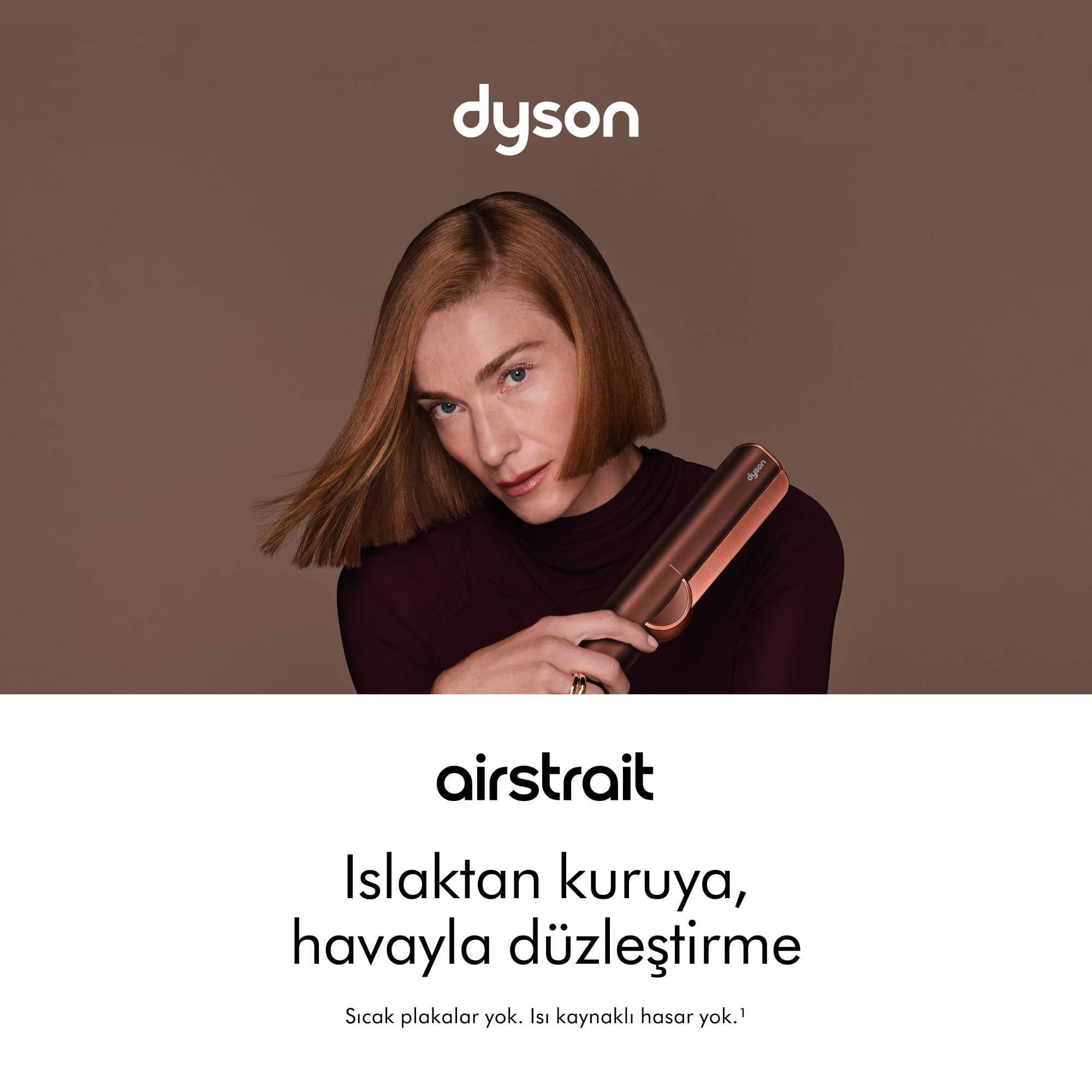 Kahverengi arka plan önünde Dyson Airstrait saç düzleştirici tutan kadın.