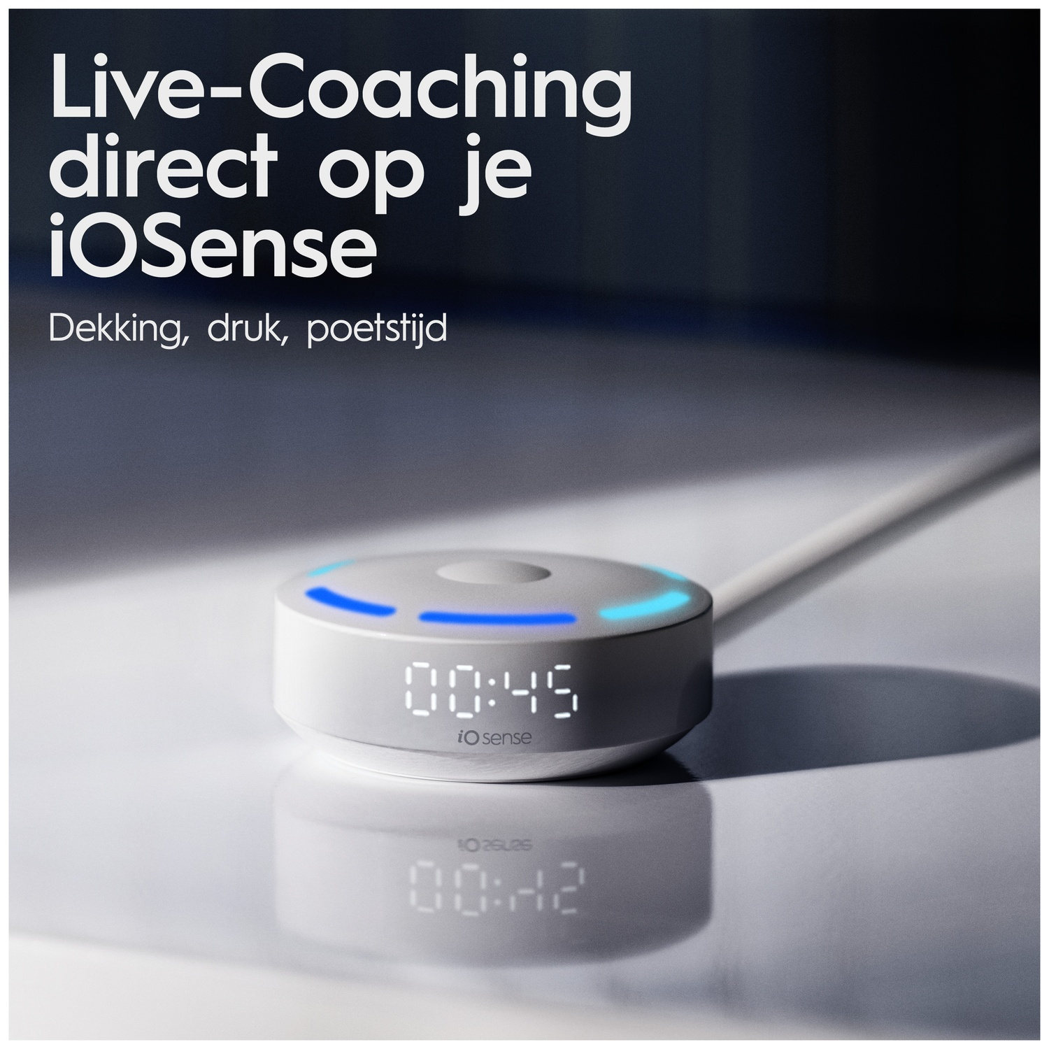 A round white ioSense device with a digital timer and glowing blue indicator light on a reflective surface.