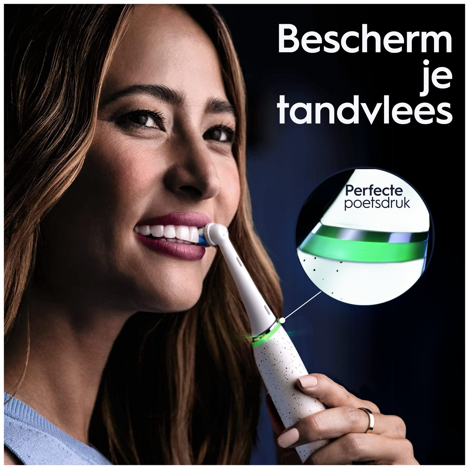 A woman smiles while holding a white electric toothbrush with a green indicator light.