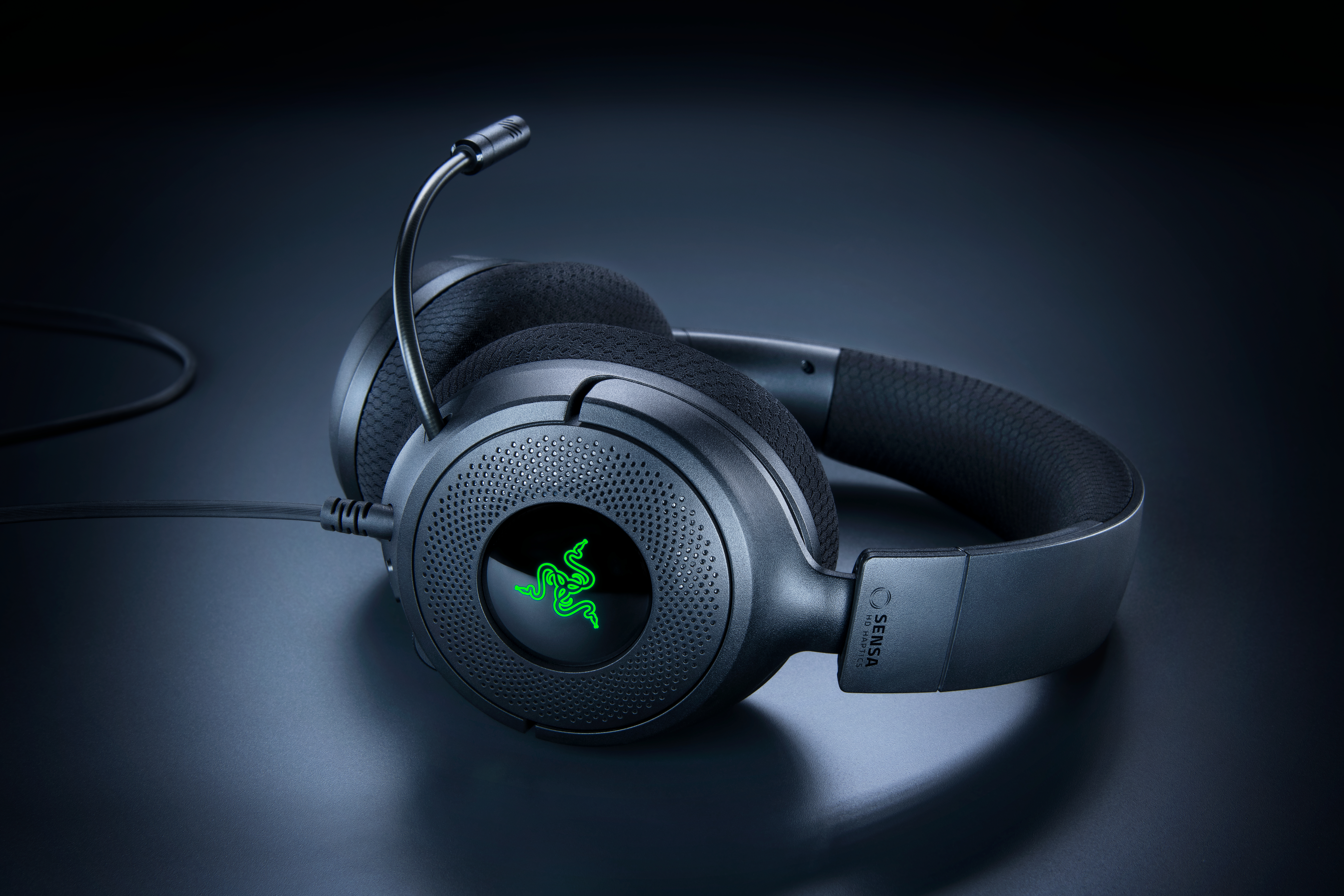 Schwarzes Razer-Gaming-Headset mit Mikrofon und grünem Logo auf dunklem Hintergrund.