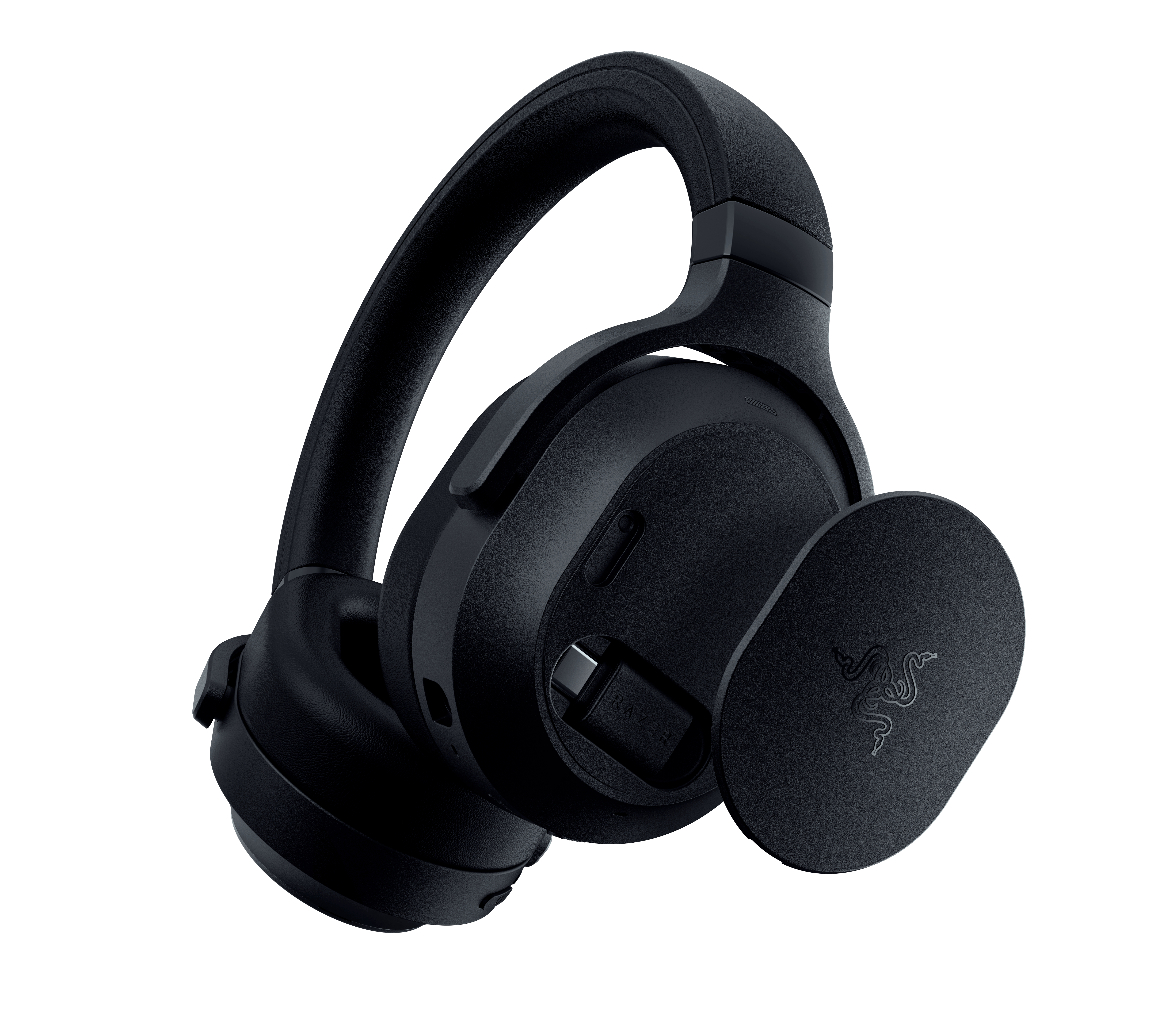 Schwarze kabellose Gaming-Kopfhörer mit abnehmbarer runder Seitenkappe und USB-C-Dongle auf weißem Hintergrund.