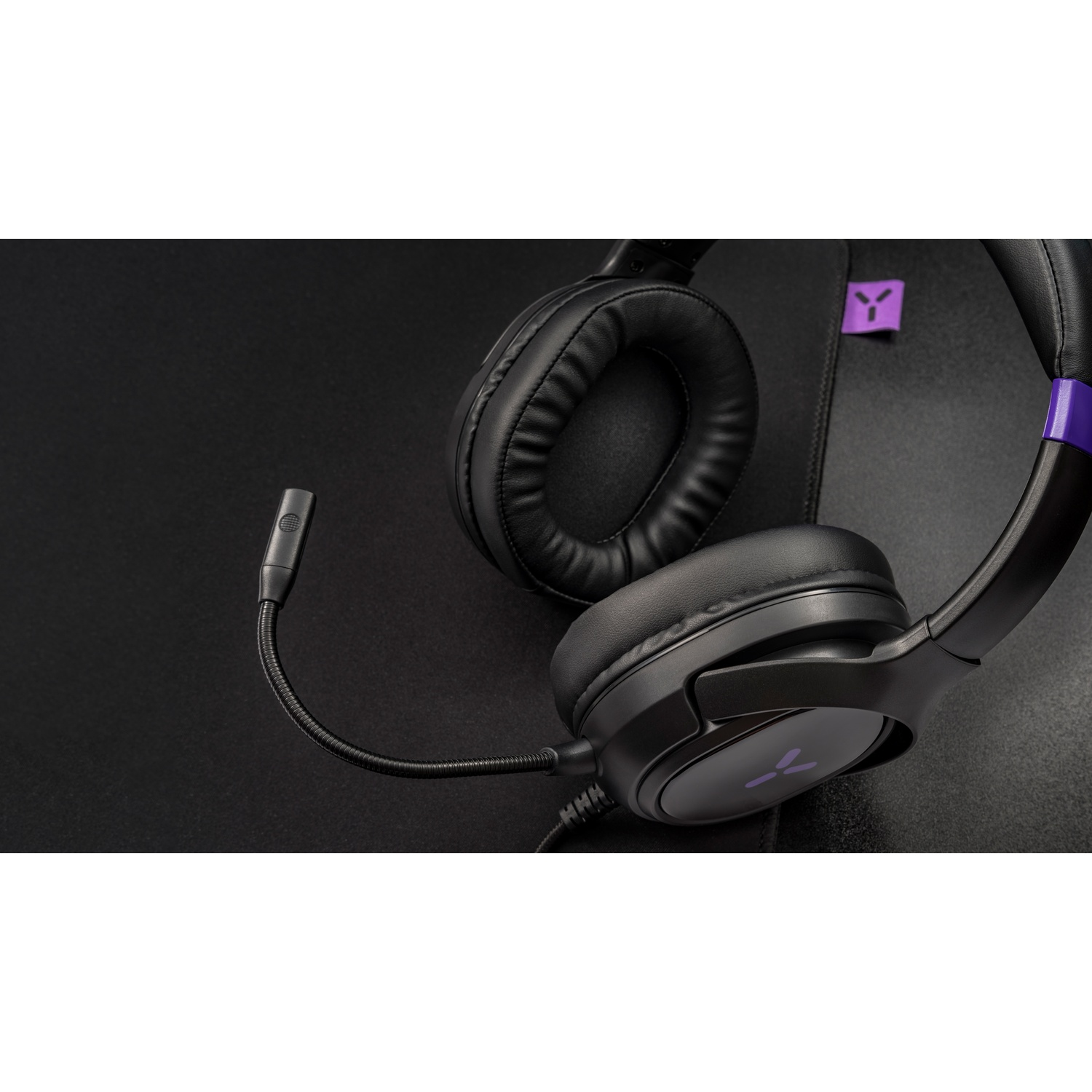 Black gaming headset with microphone on a dark background.
