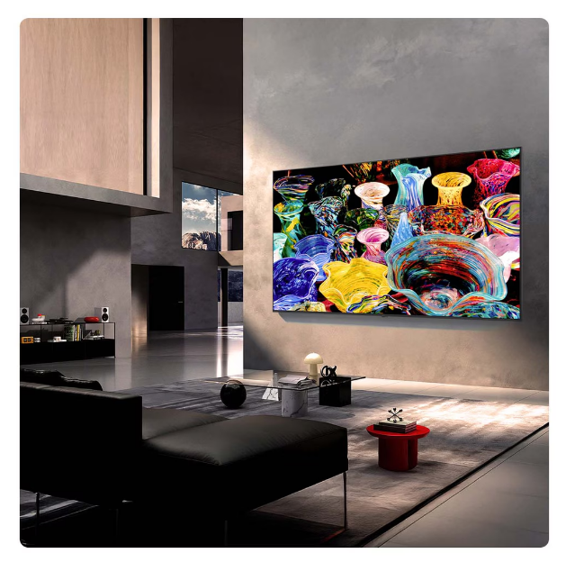 Duvarında büyük TV, koyu renk kanepe ve halı olan modern oturma odası.