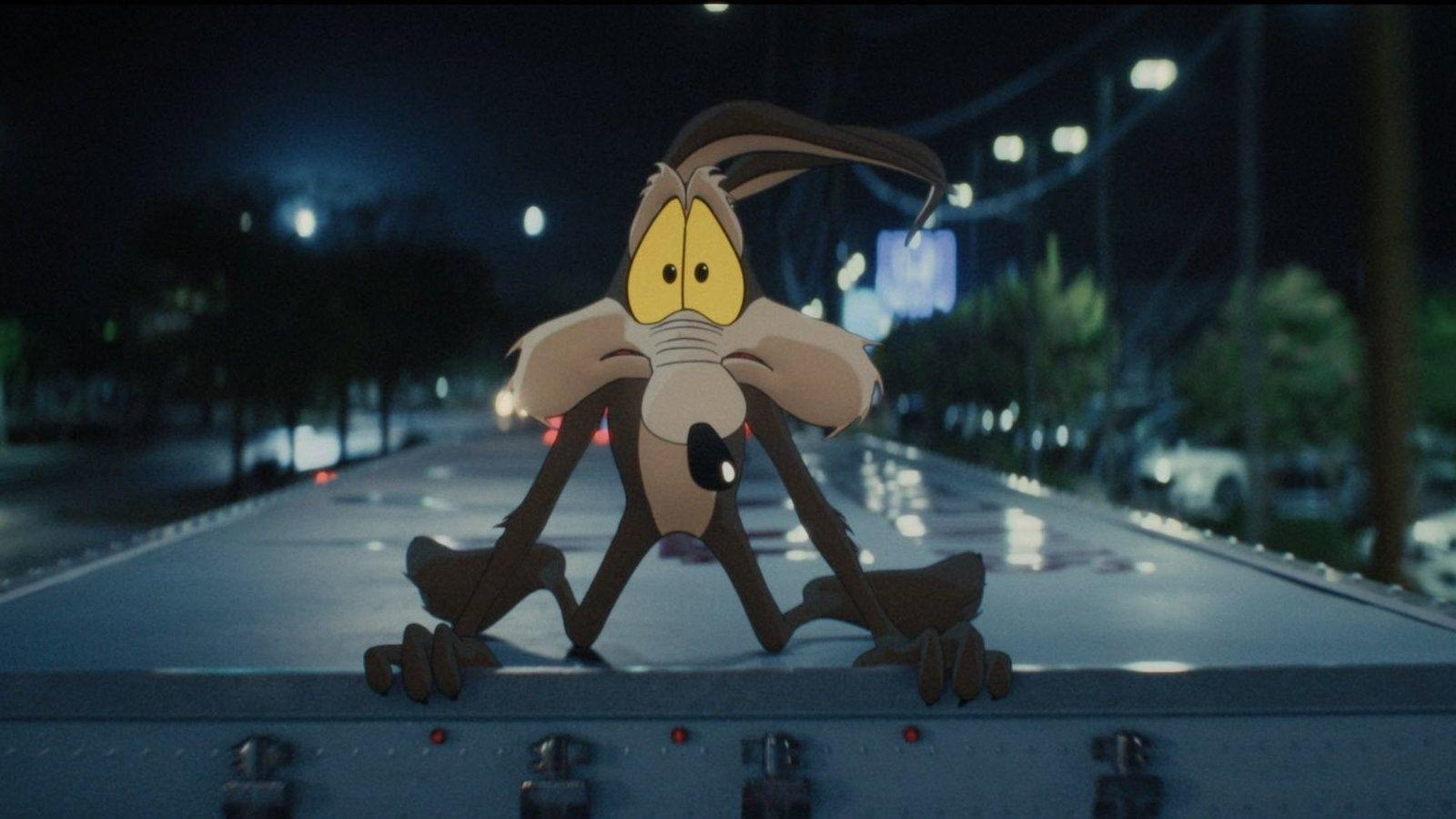 Wile E. Coyote steht nachts auf dem Dach eines fahrenden Lastwagens.