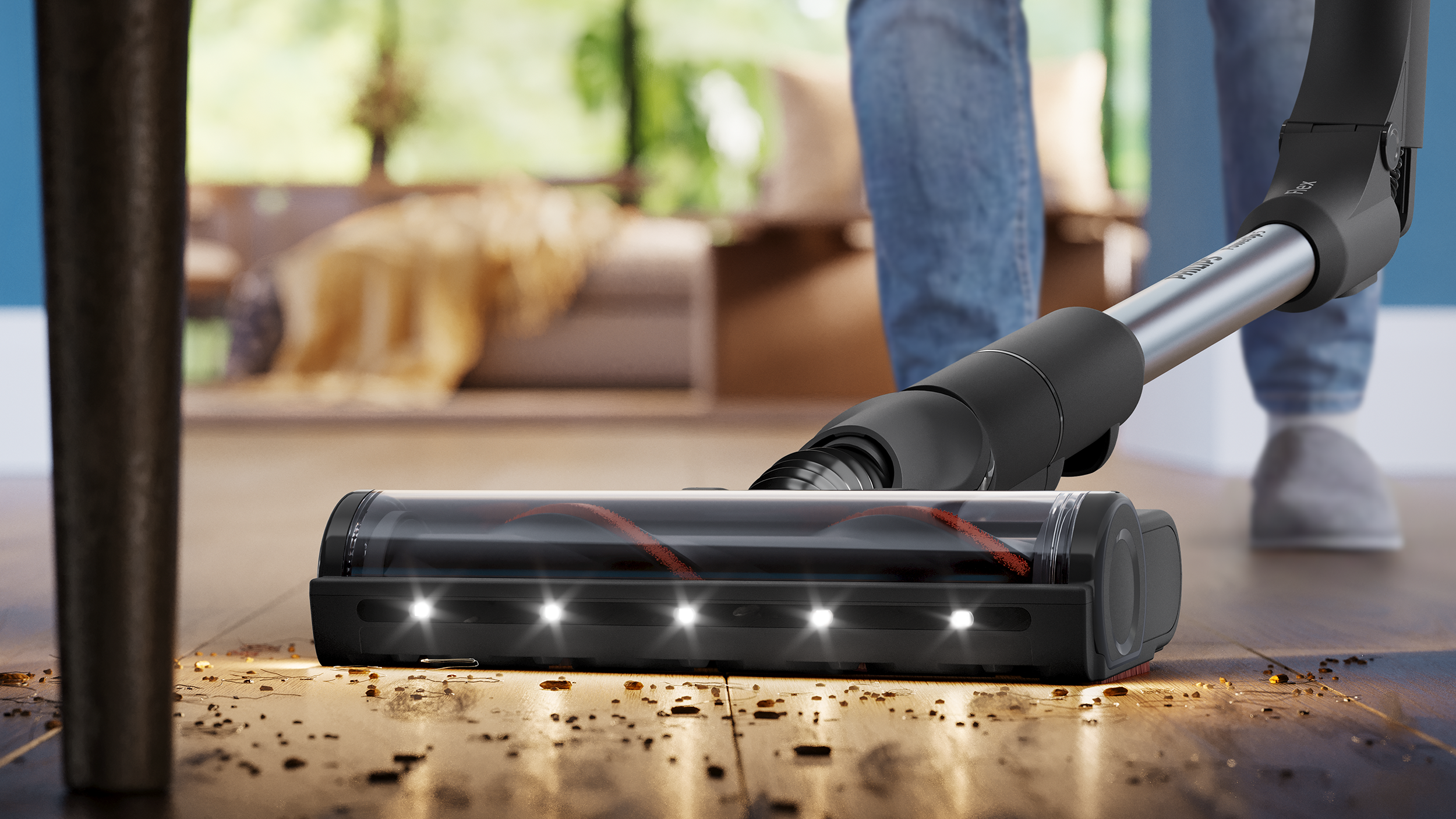 Egy LED-es porszívó tisztítja a fapadlót, amelyen szennyeződés van.