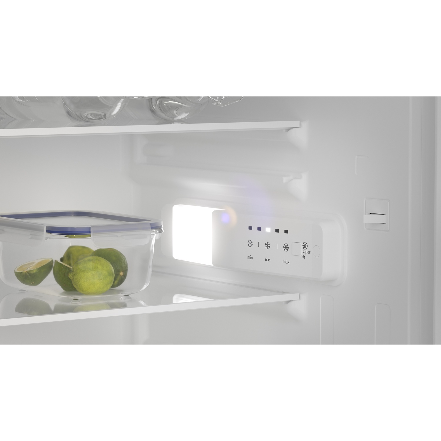 Illuminated refrigerator interior with a box of limes on the glass shelf and a digital temperature control panel.