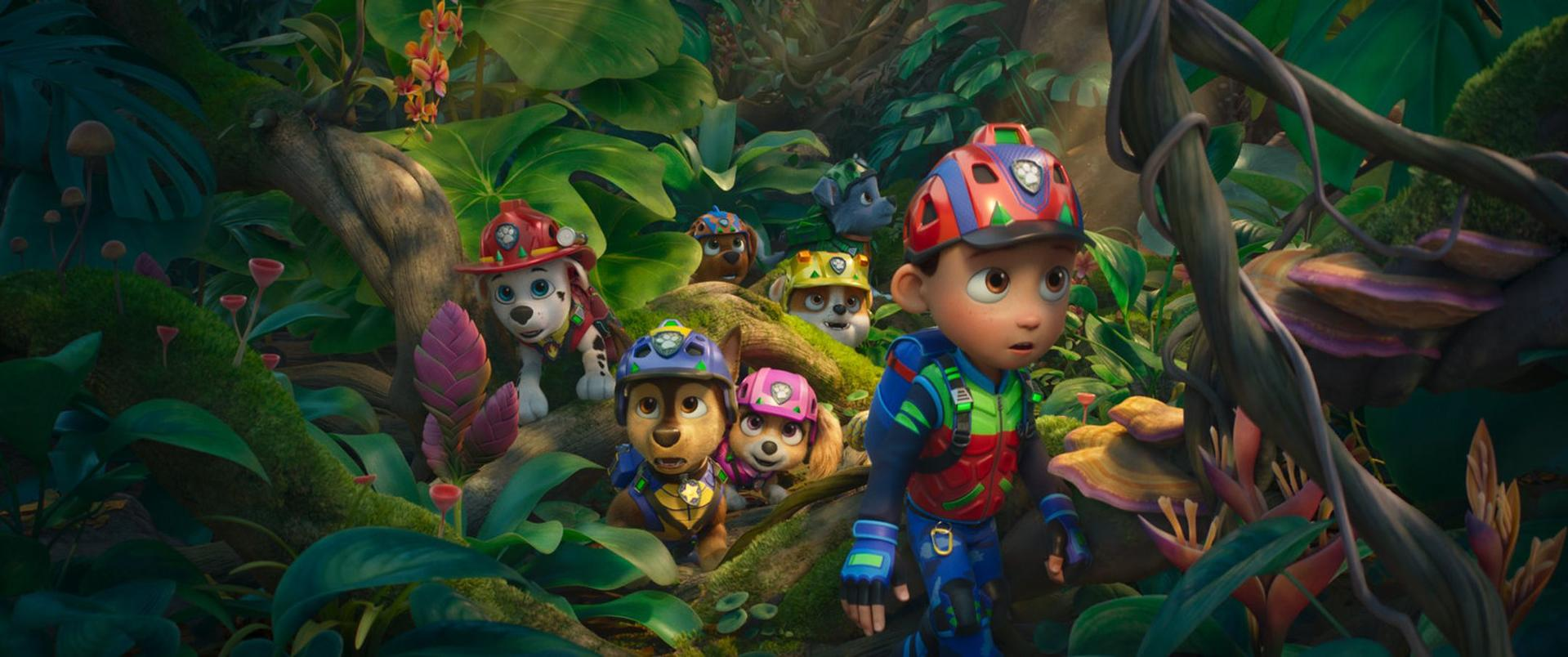 Ryder und Welpen der Paw Patrol wandern vorsichtig durch einen dichten, grünen Dschungel.