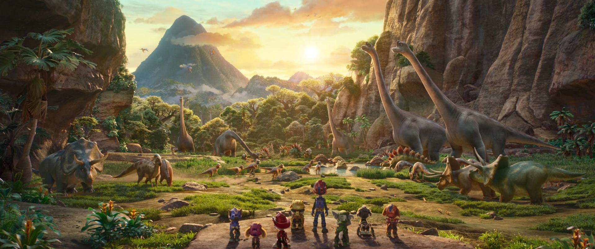 Eine Gruppe kleiner Figuren blickt in ein Tal voller verschiedener Dinosaurier bei Sonnenuntergang.