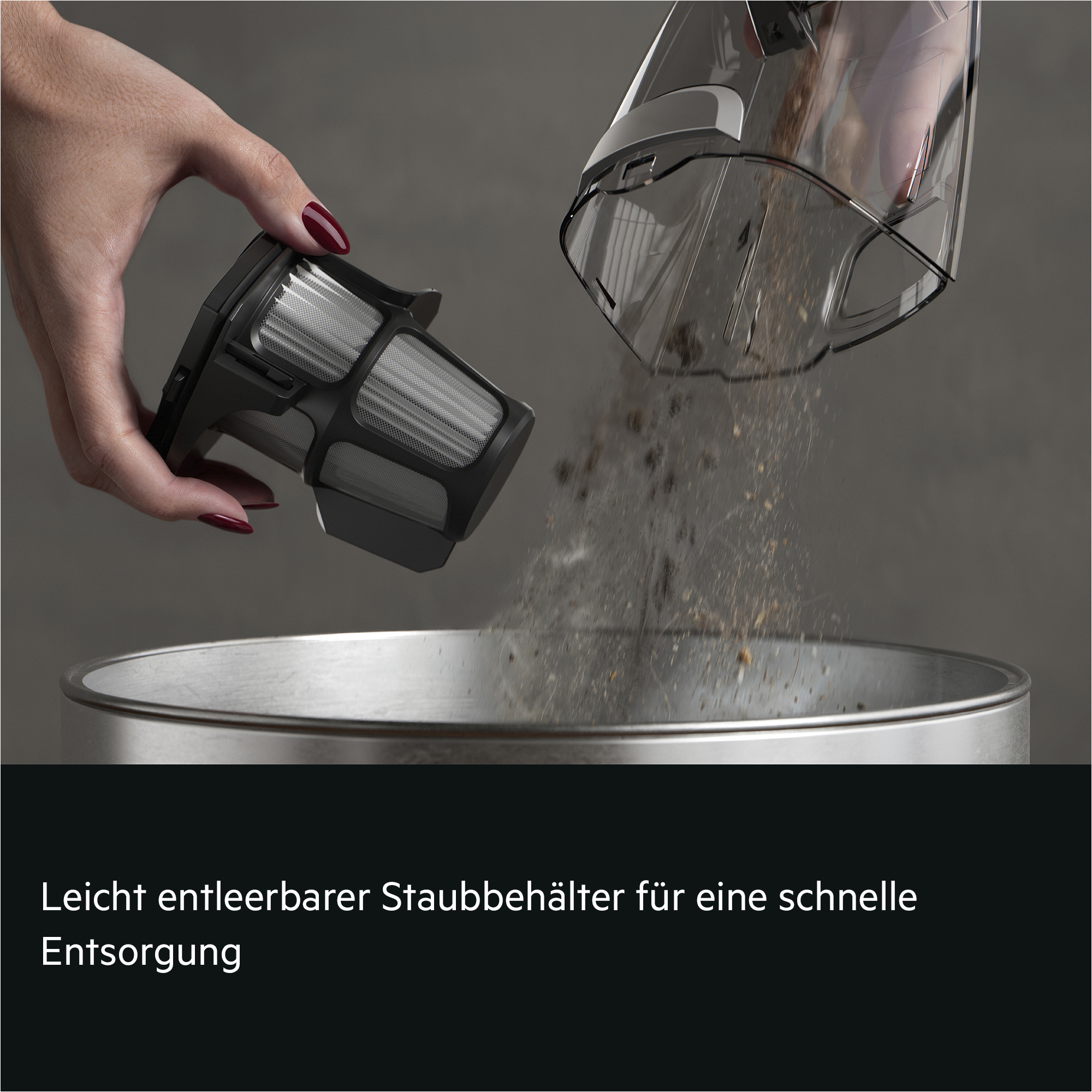 Staubbehälter wird in einen Eimer entleert, Filter wird separat gehalten.