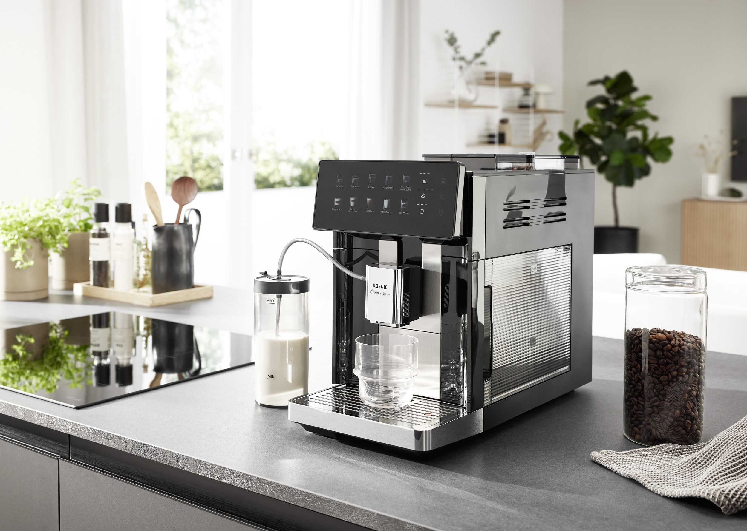 Moderne Kaffeemaschine auf einer Küchenarbeitsplatte mit Milchbehälter, Kaffeebohnen und einem Glas.