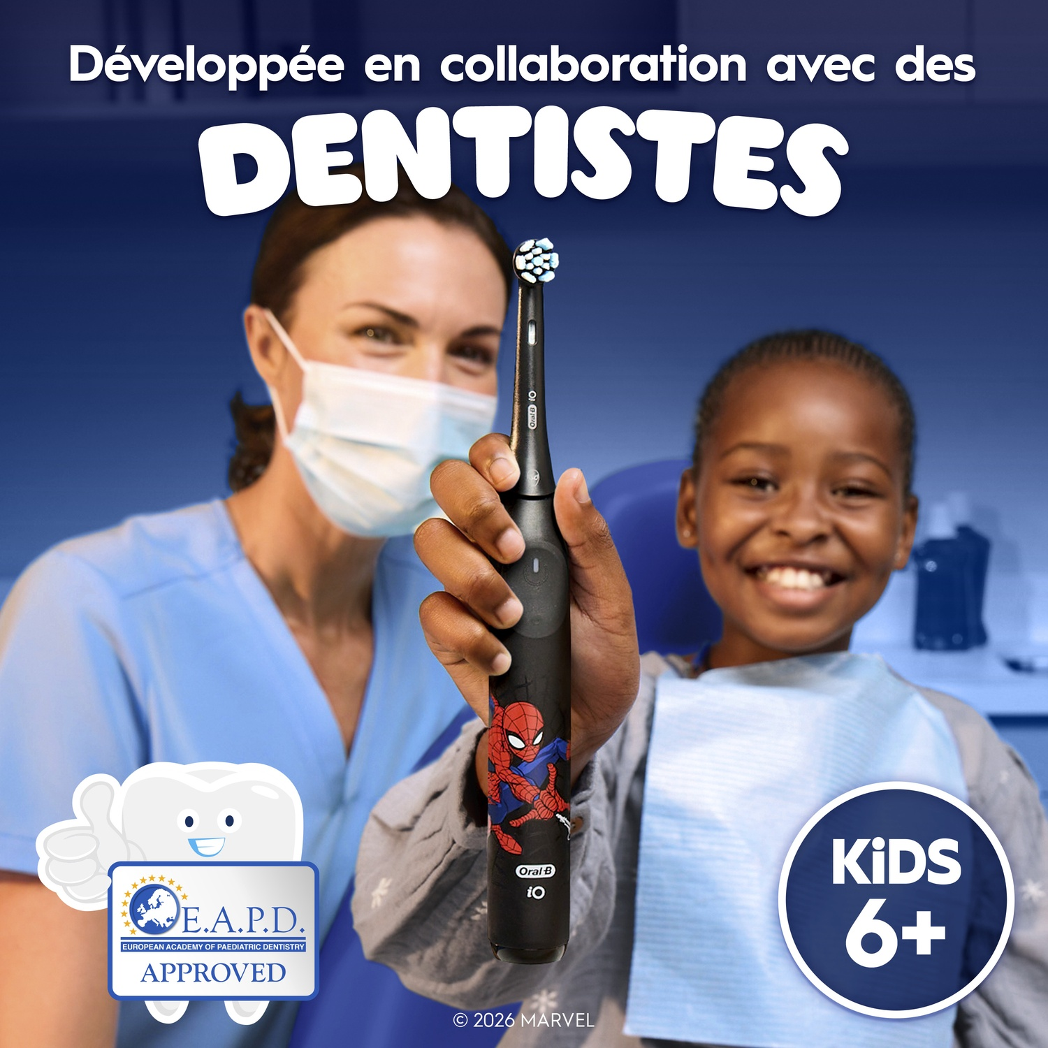 Un enfant tient une brosse à dents électrique Spider-Man près d'un dentiste.