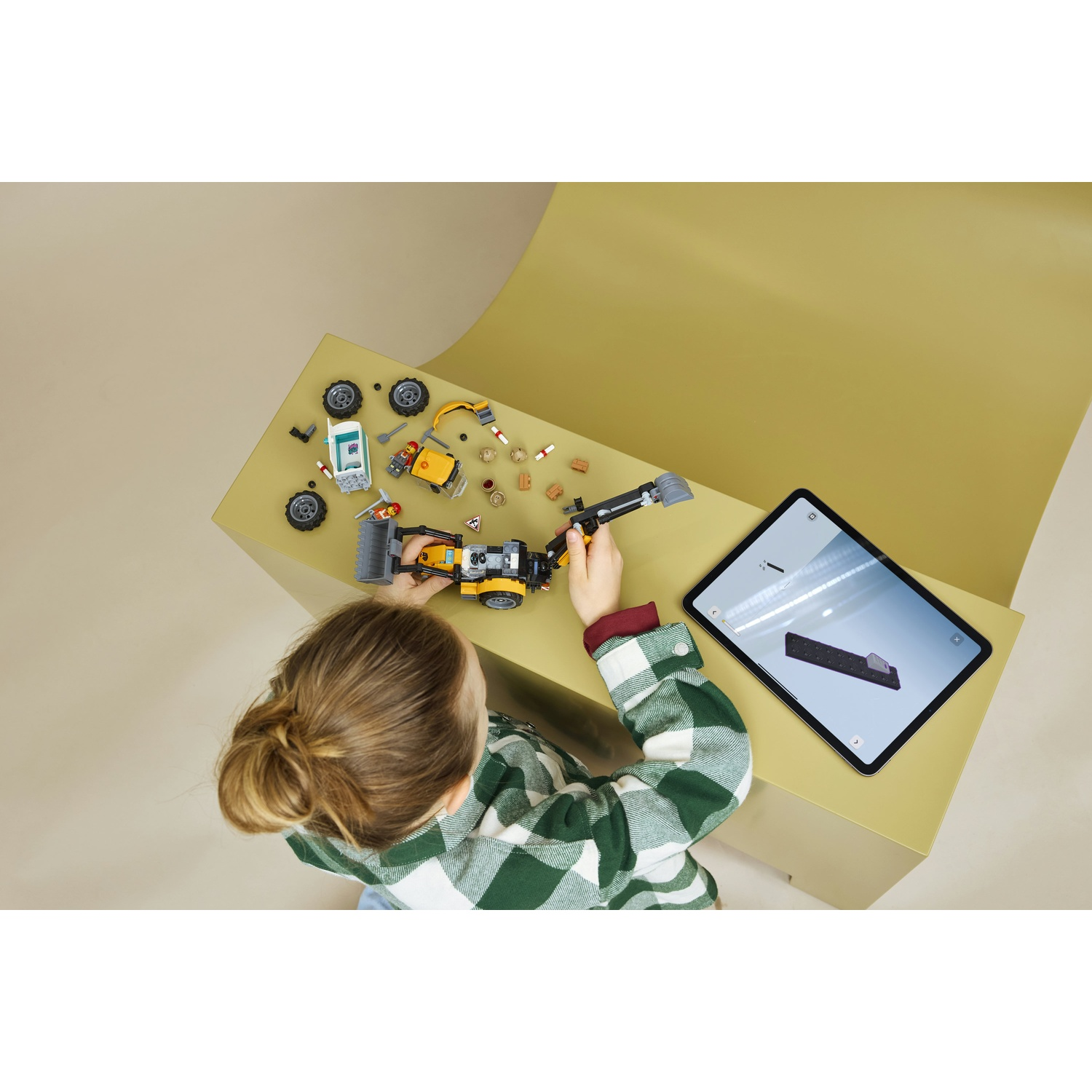 Un bambino costruisce un modello Lego usando istruzioni digitali su un tablet.