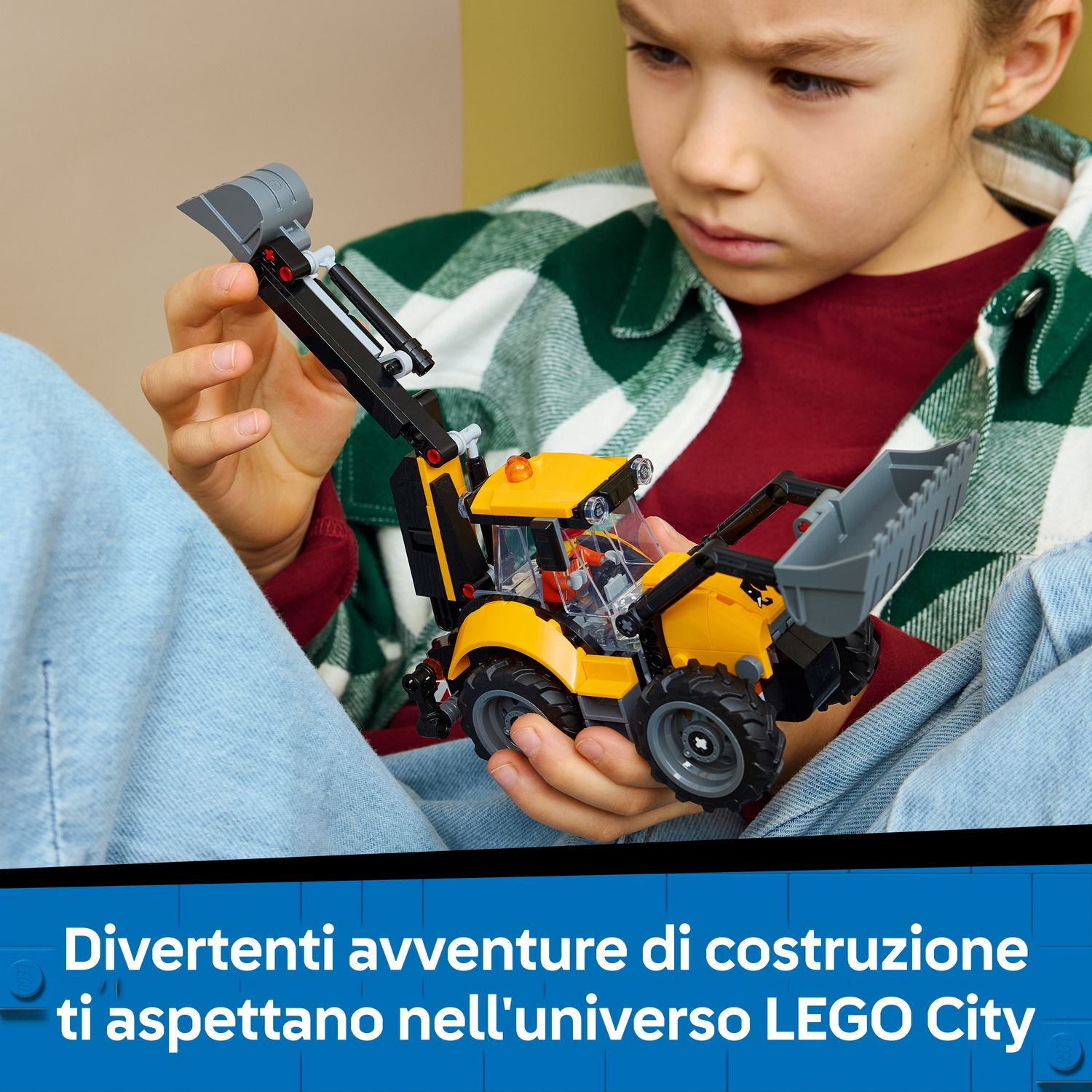 Un bambino tiene in mano una terna LEGO gialla e nera, guardandola con concentrazione.