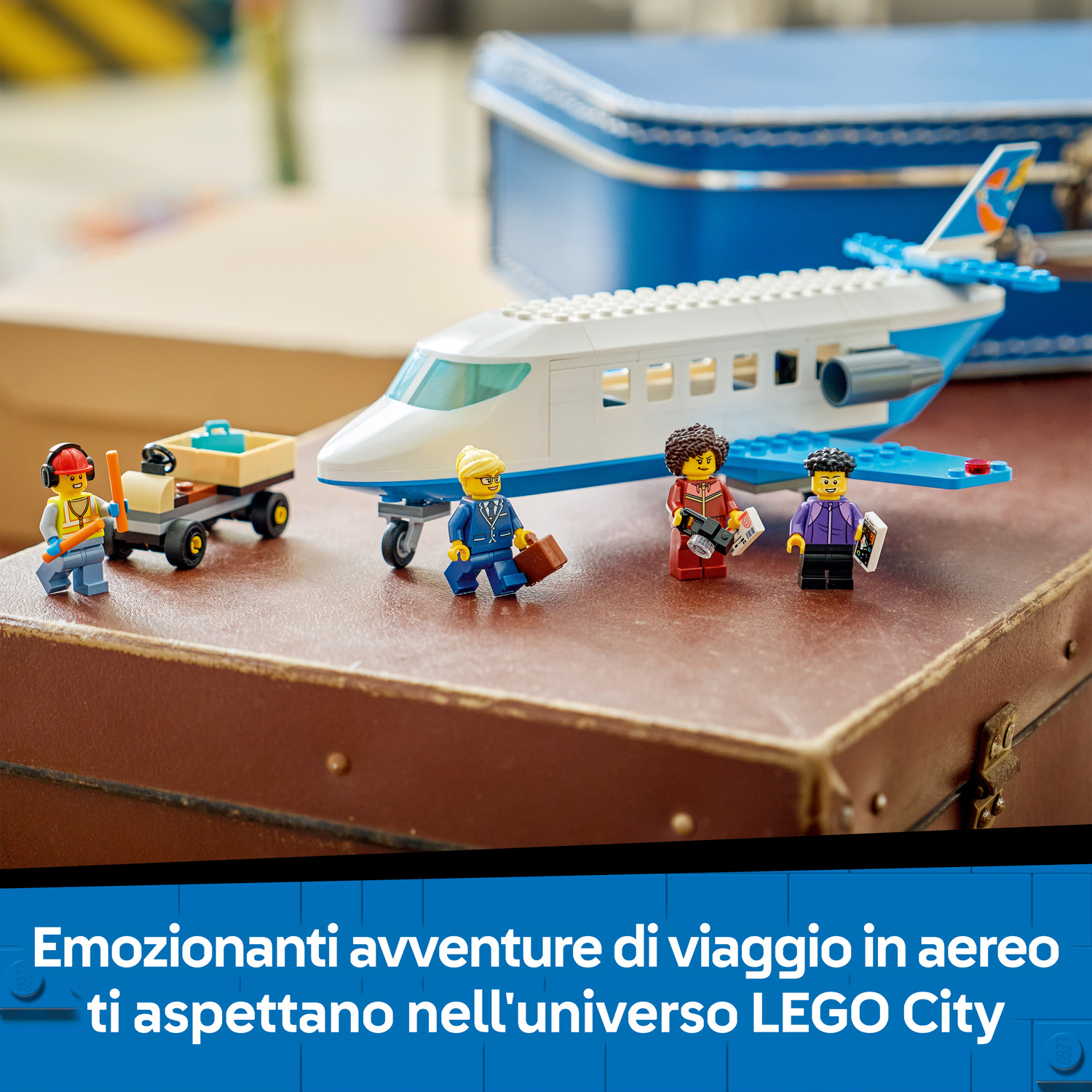 Aereo passeggeri Lego su una valigia marrone con quattro minifigure Lego e un carrello porta bagagli.