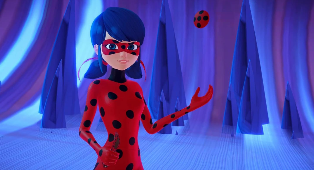 Ladybug in einem roten, schwarz gepunkteten Kostüm steht vor blauen Kristallen, während ein kleiner Ball schwebt.