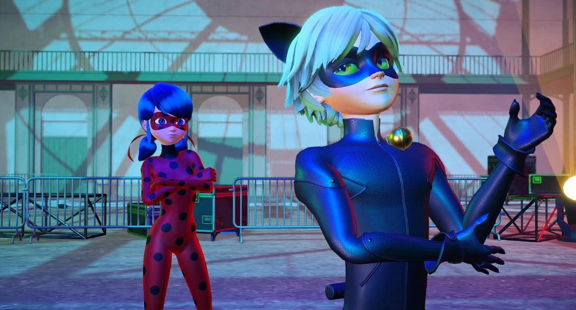 Ladybug und Cat Noir stehen an einem metallenen Zaun auf einem großen Platz bei Tageslicht.