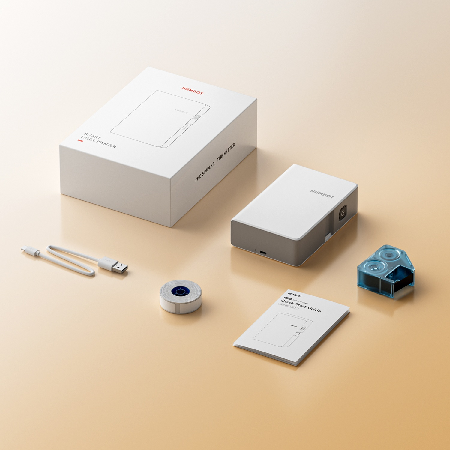 A white Niimbot label printer with box, USB cable, label roll, manual, and tape cartridge on a beige background.