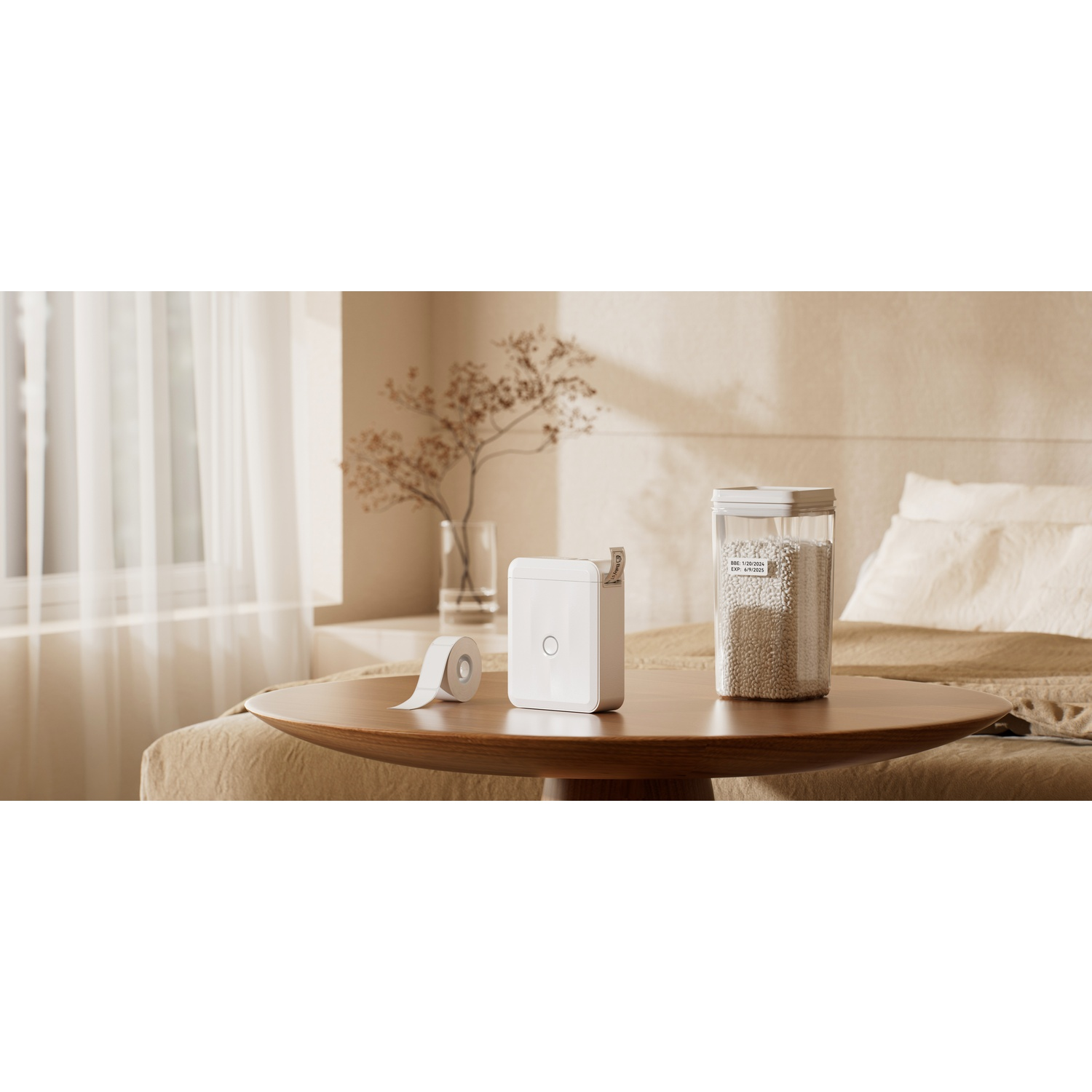 A white label maker and label roll on a wooden table in a bedroom, with a labeled container of grains in the background.