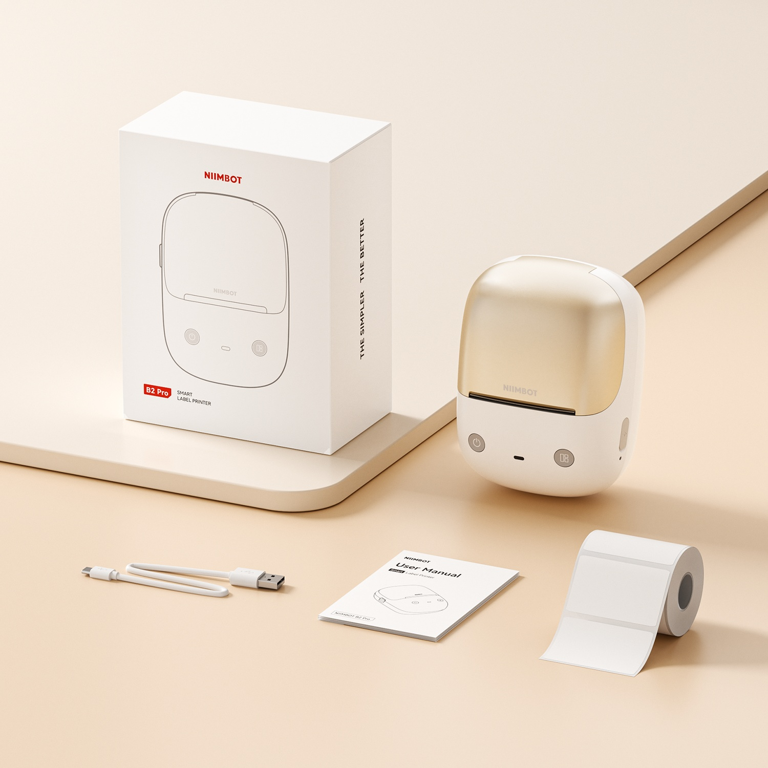 A white Niimbot B2 Pro label printer with box, USB cable, user manual, and label roll.