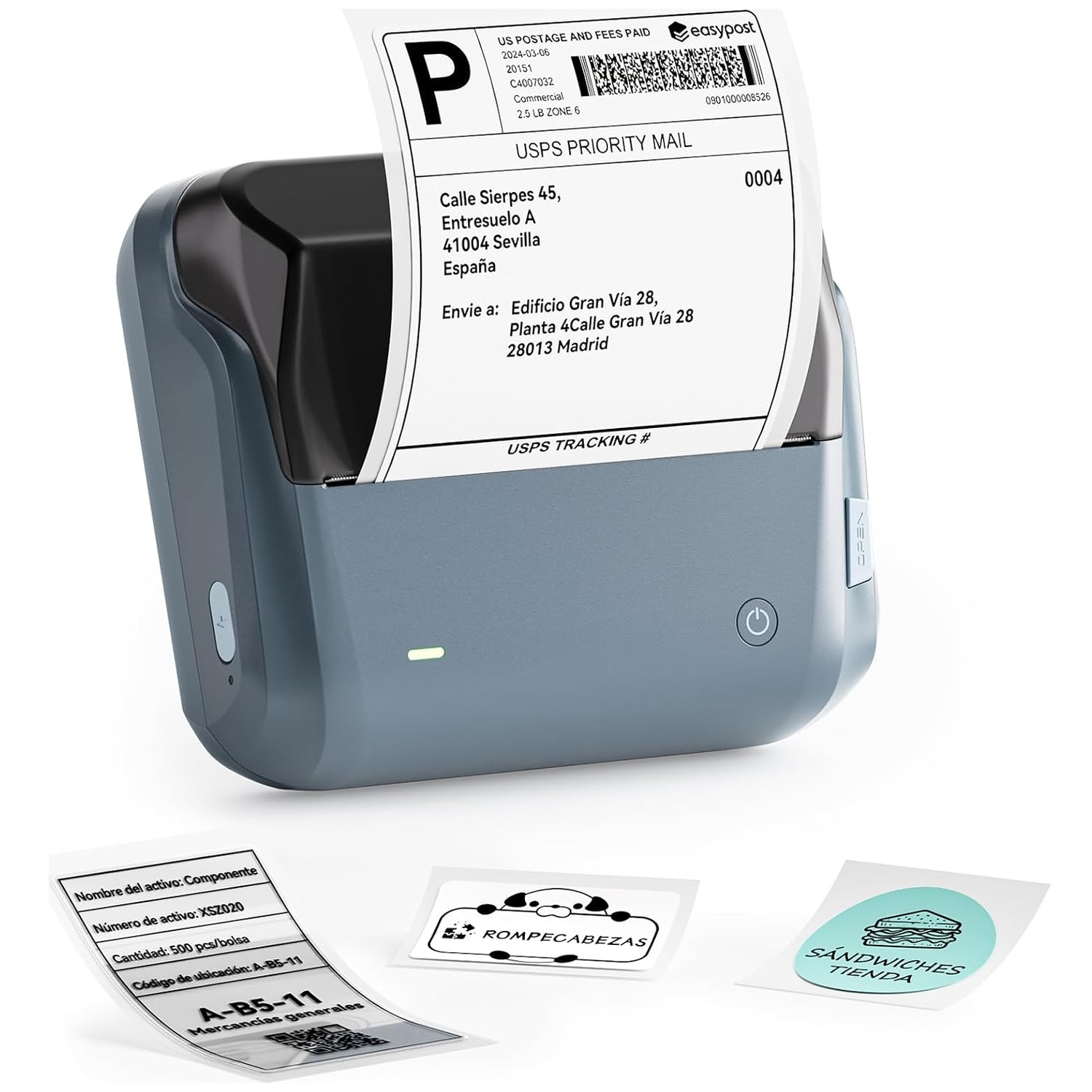 A blue and black thermal label printer printing a USPS shipping label, with extra printed labels on white surface.