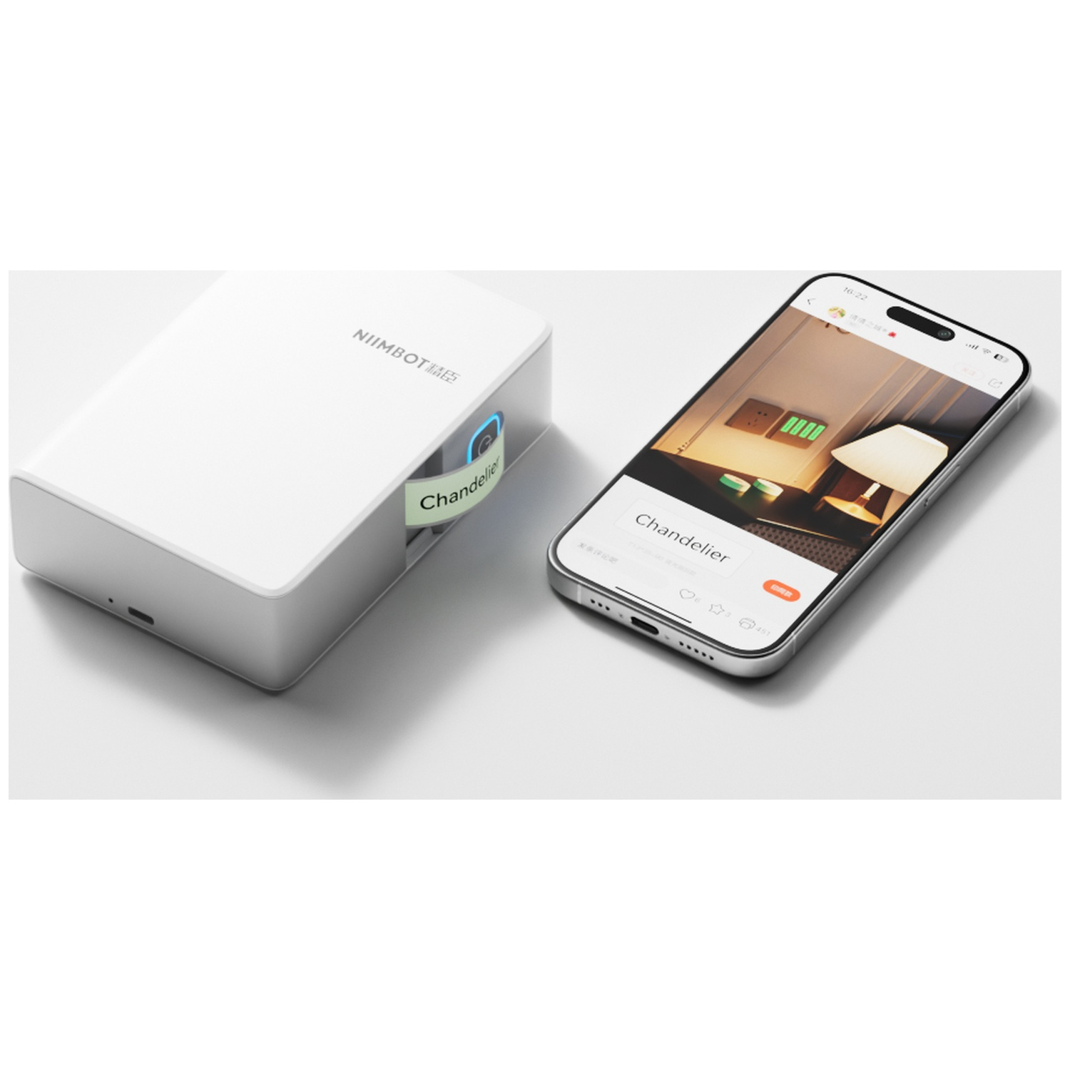 A white Niimbot label printer and a smartphone showing a mobile app on a white surface.