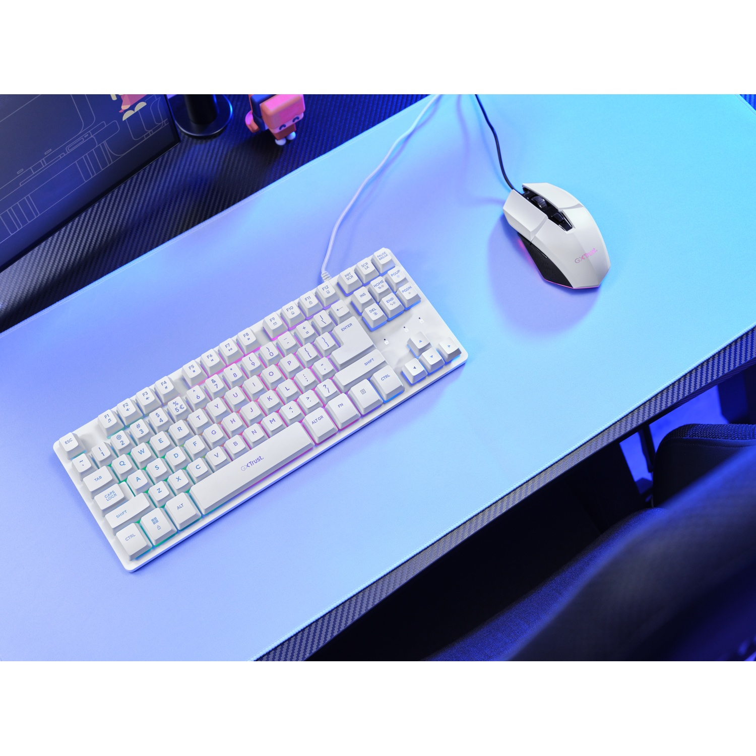 A white keyboard and mouse sit on a light blue desk mat with blue lighting effects.
