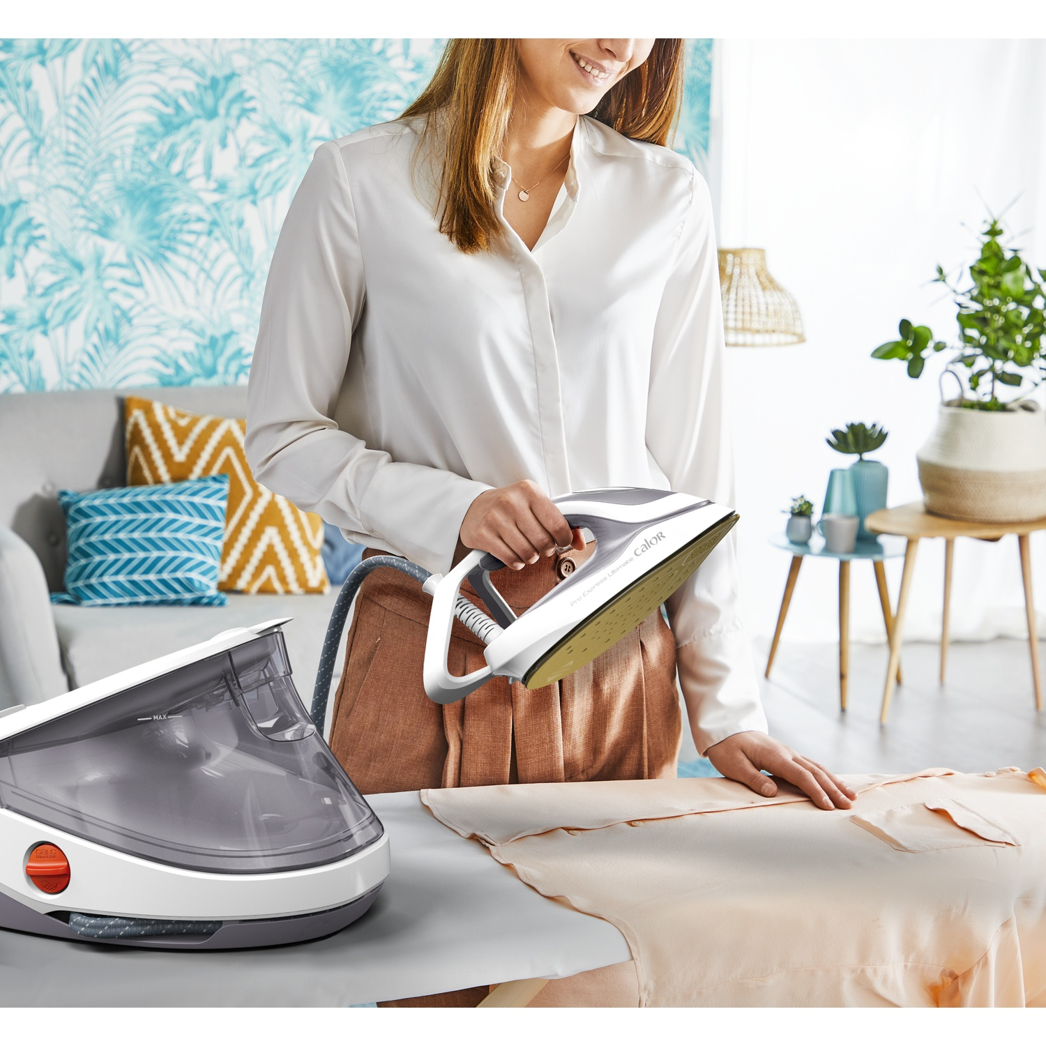 A woman ironing a light shirt with a steam generator iron in a sunny room.