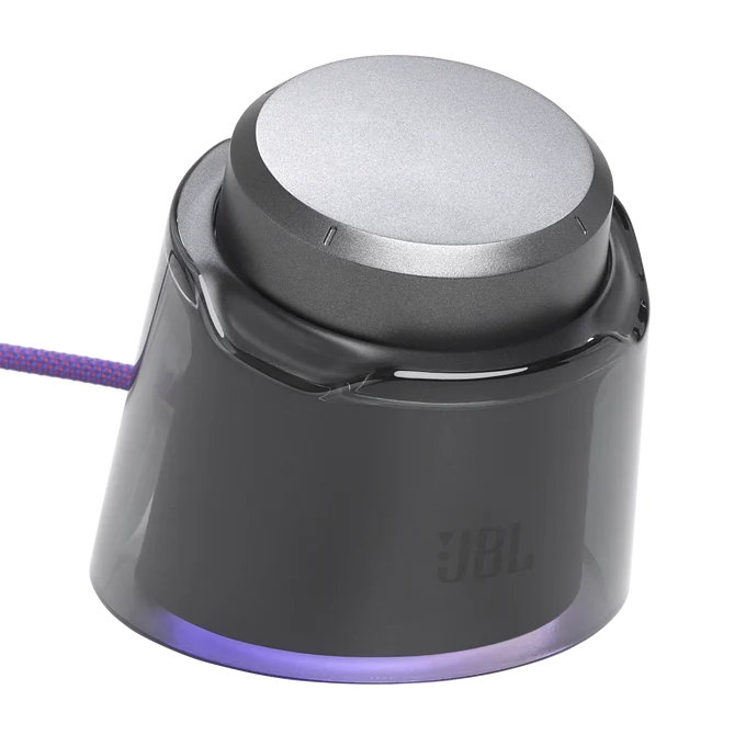 Un control de volumen JBL gris en forma de cono con cubierta transparente y cable morado sobre fondo negro.