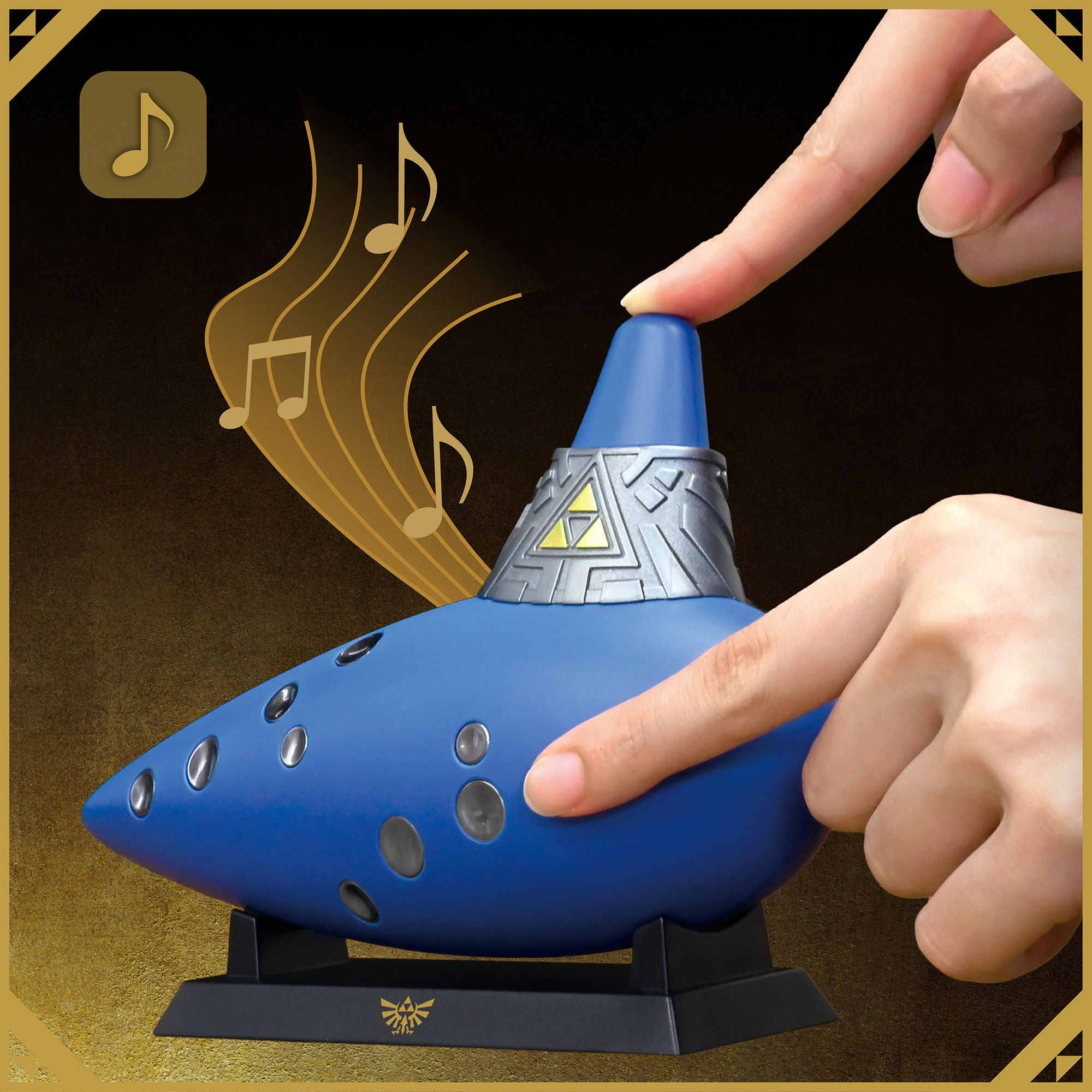Eine blau-silberne Okarina auf Ständer wird gespielt, mit goldenen Noten im Hintergrund.