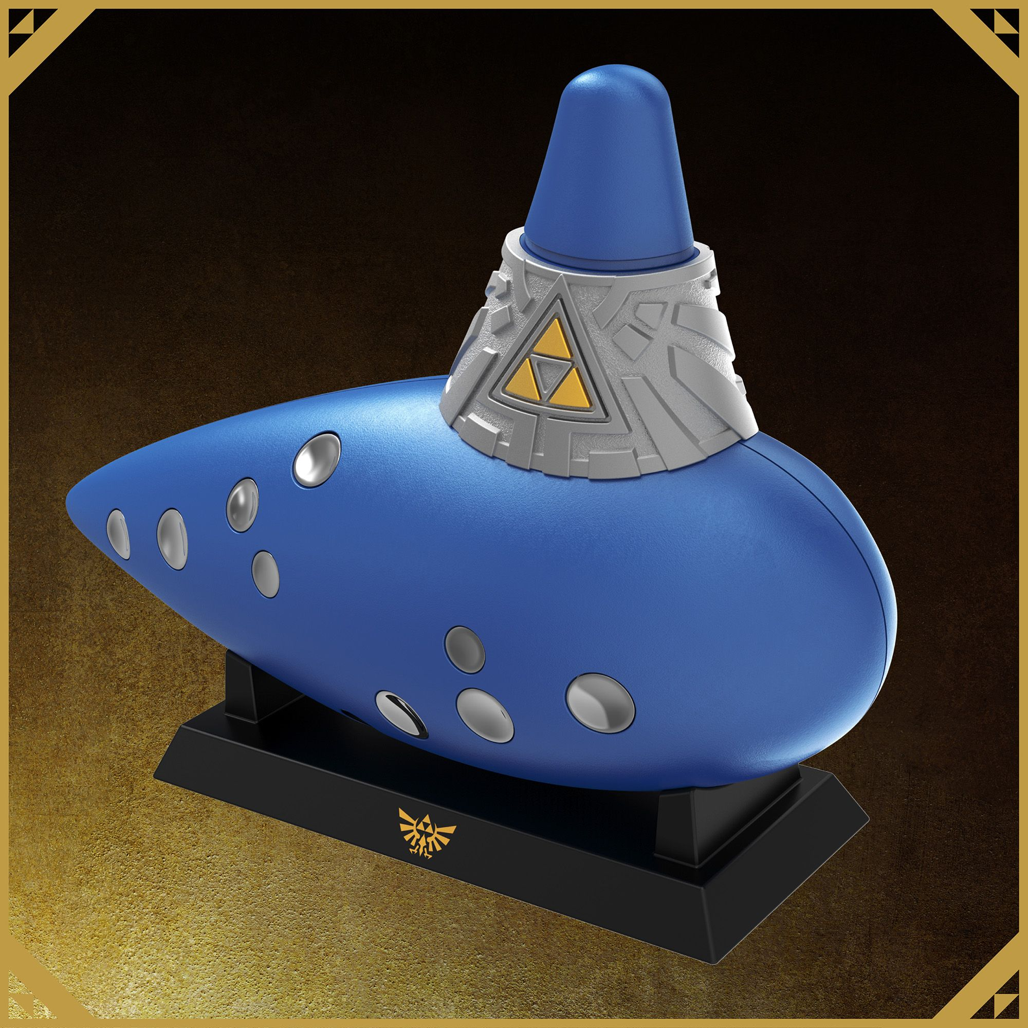 Blaue Okarina mit silbernem Hals, goldenem Triforce-Symbol und silbernen Löchern auf einem schwarzen Ständer vor braunem Hintergrund.