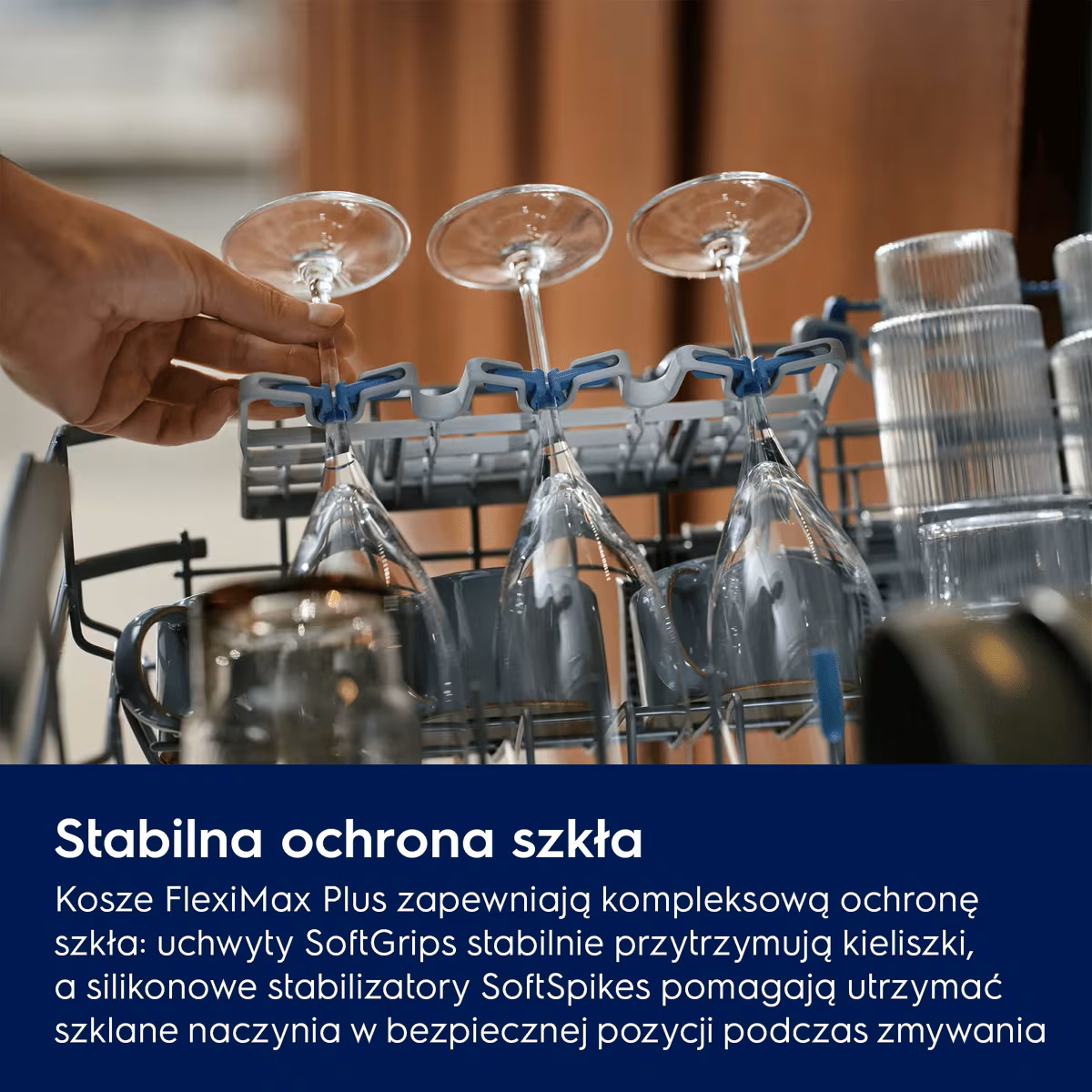 Ręka umieszcza kieliszki w elastycznych uchwytach otwartej zmywarki.
