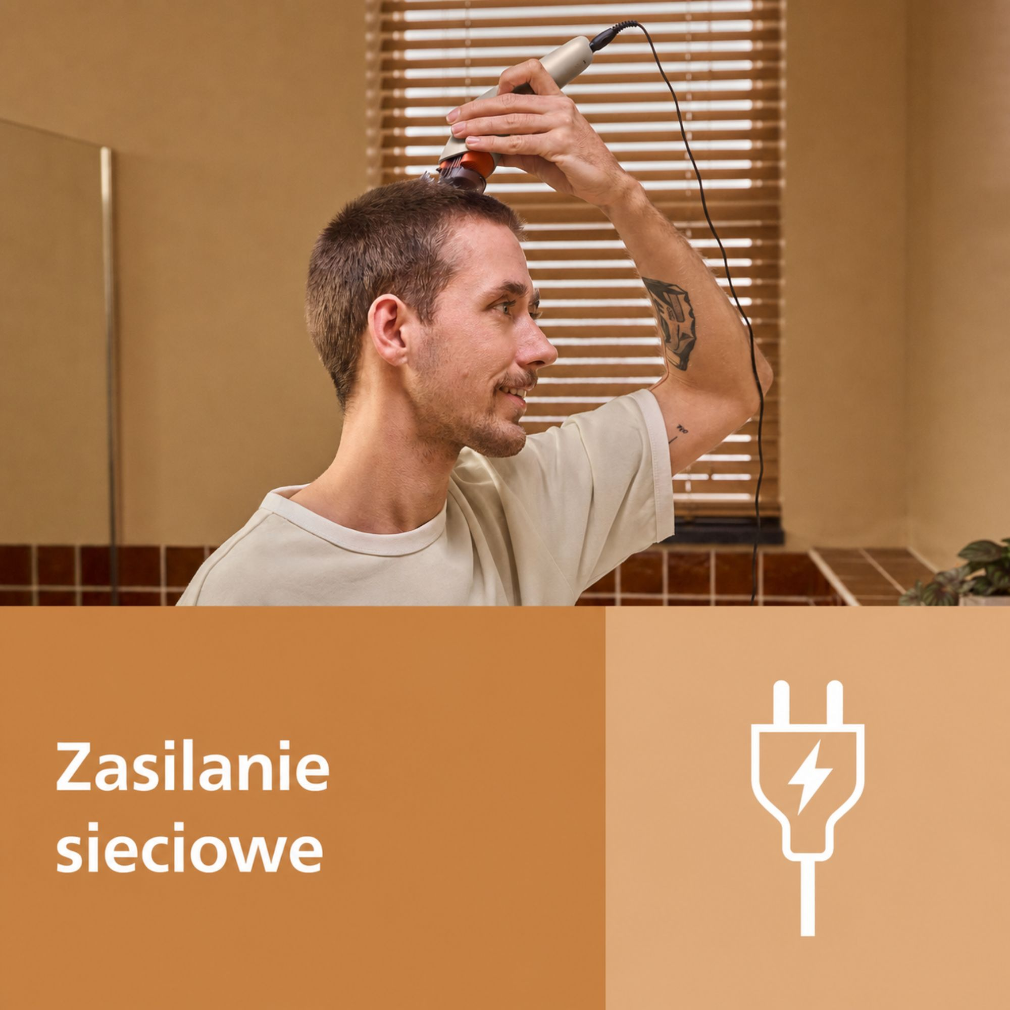 Mężczyzna przycina włosy przewodową maszynką. Poniżej znajduje się ikona wtyczki.