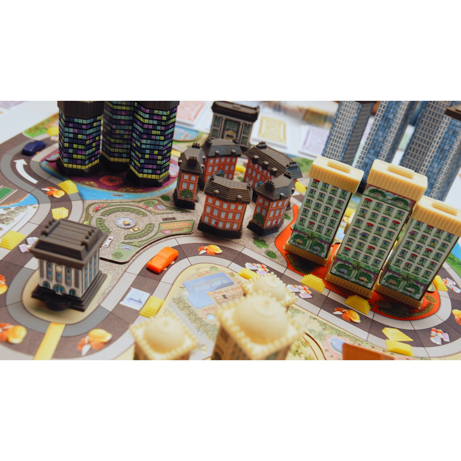 A colorful monopoly-style board game featuring various 3D buildings, roads, and miniature cars on a map.