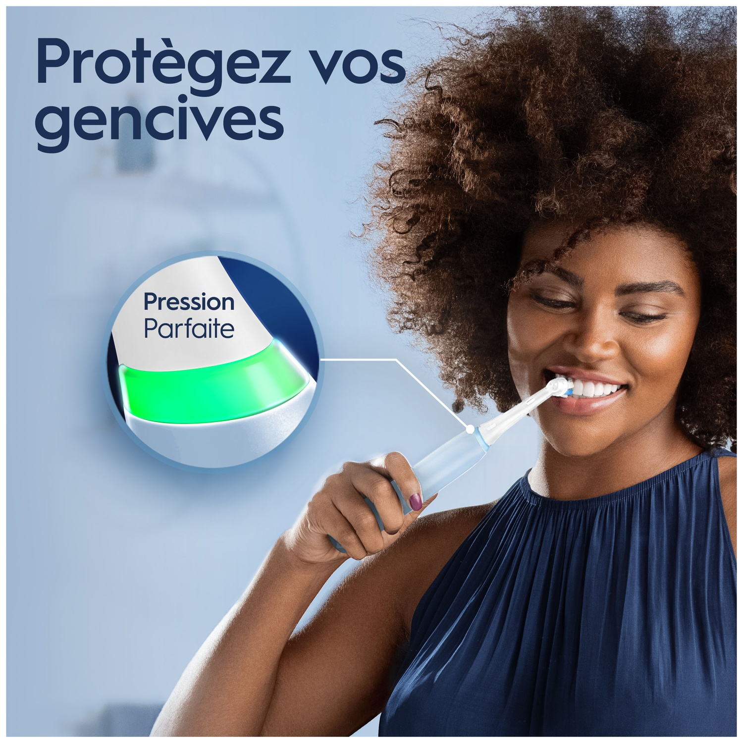 Une femme sourit en se brossant les dents avec une brosse à dents électrique.